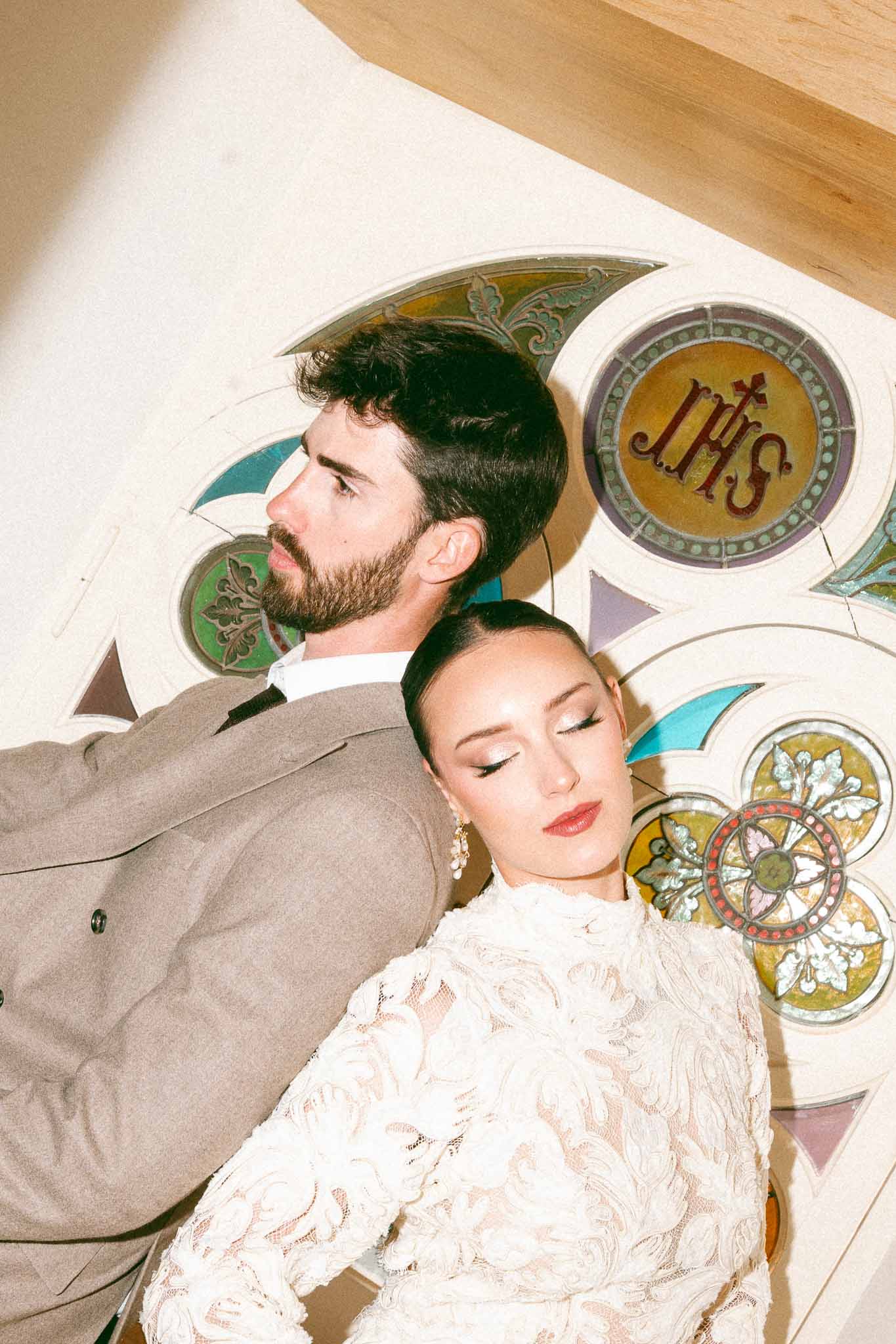 Bride and groom portrait against decorative religious wall at traditional indoor venue