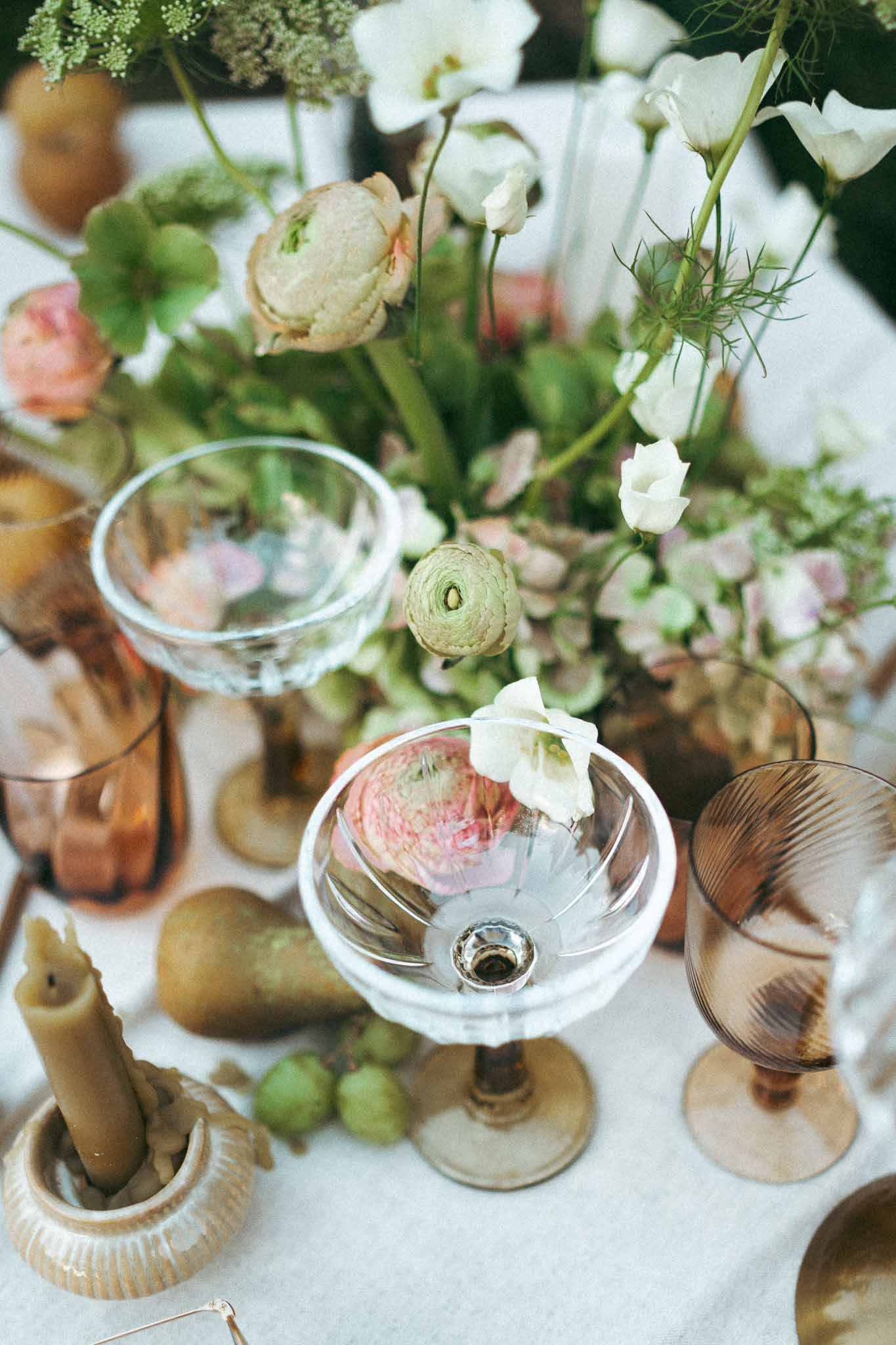 Overhead view of wedding table setting with floral arrangements and glassware at garden reception
