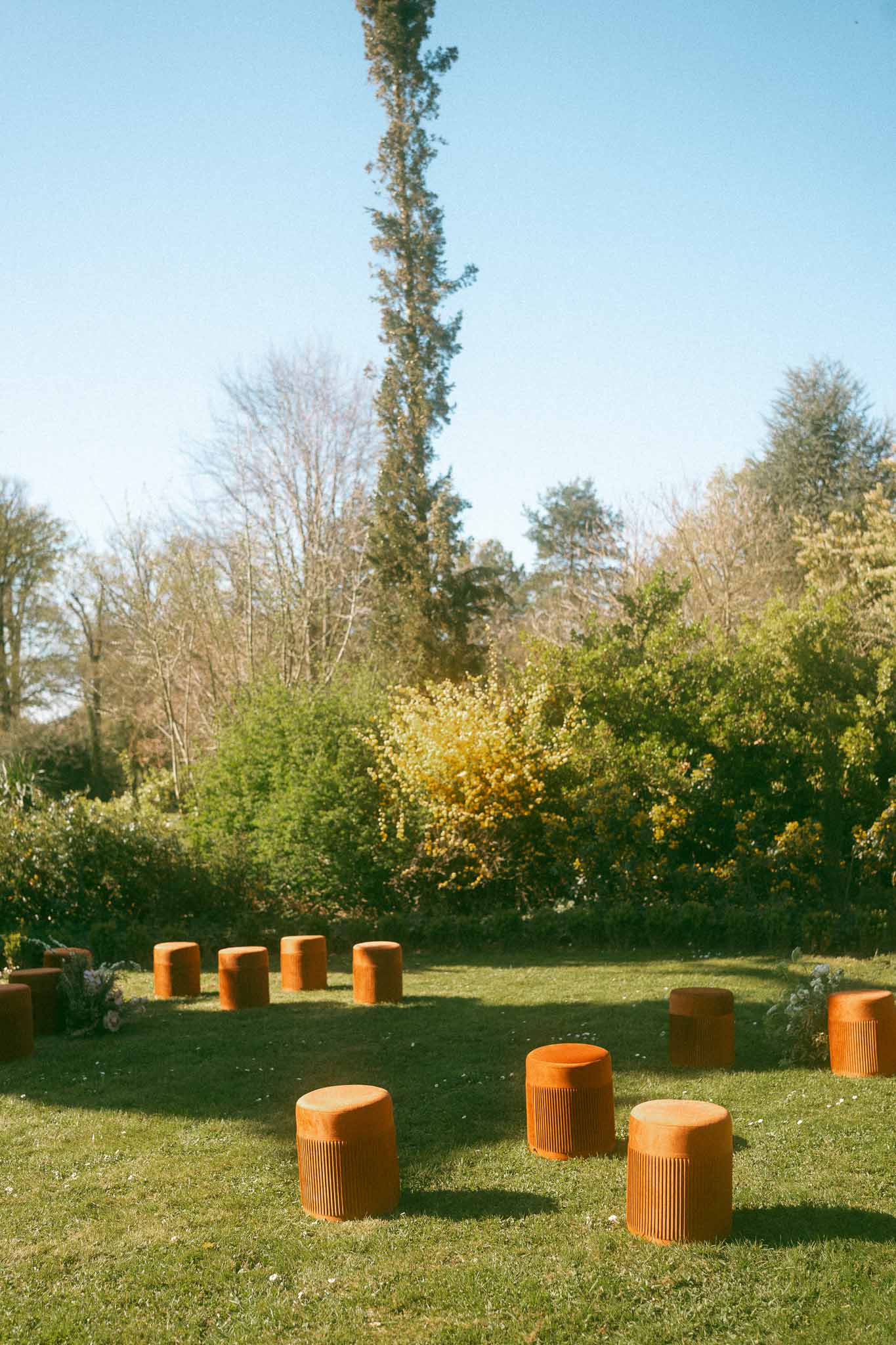 Outdoor garden wedding venue setup with terracotta seating elements and mature trees