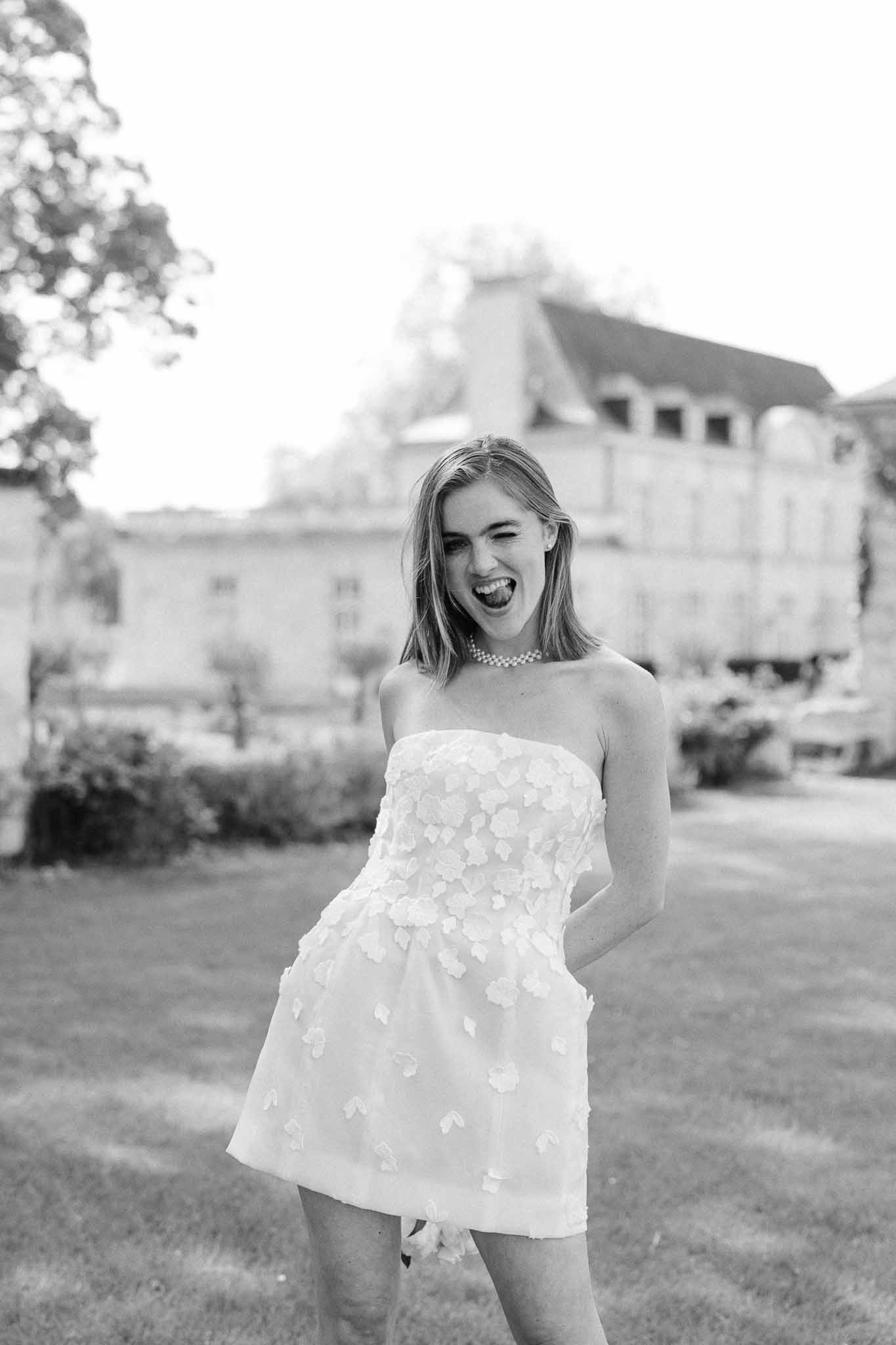 Bride in strapless dress with floral appliqués posing outdoors at historic stone château