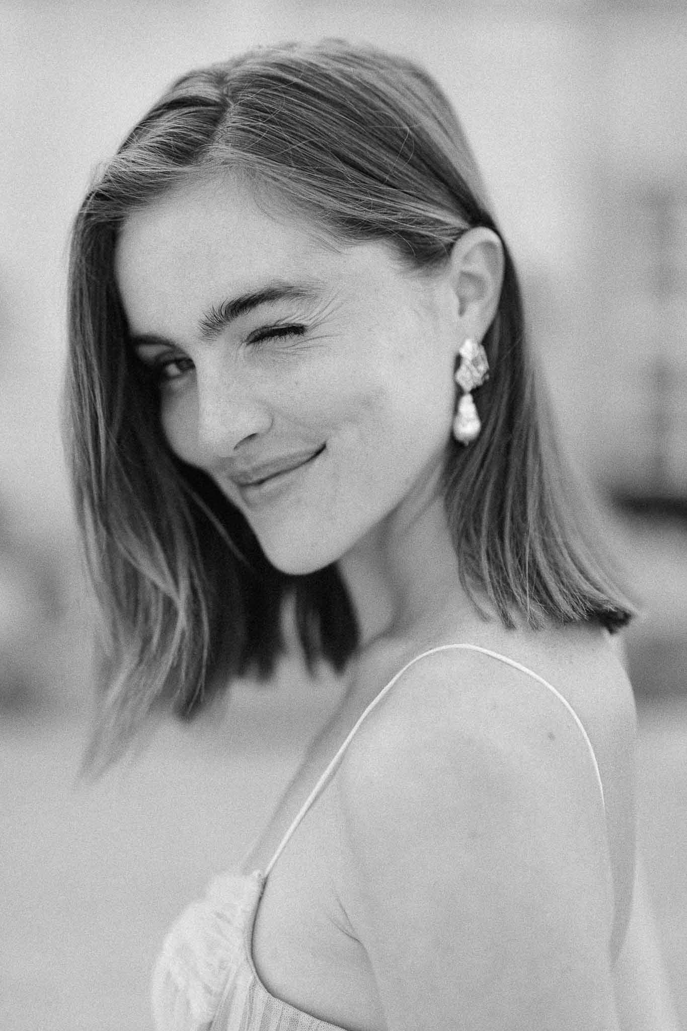 Black and white bridal portrait with pearl earrings at wedding venue