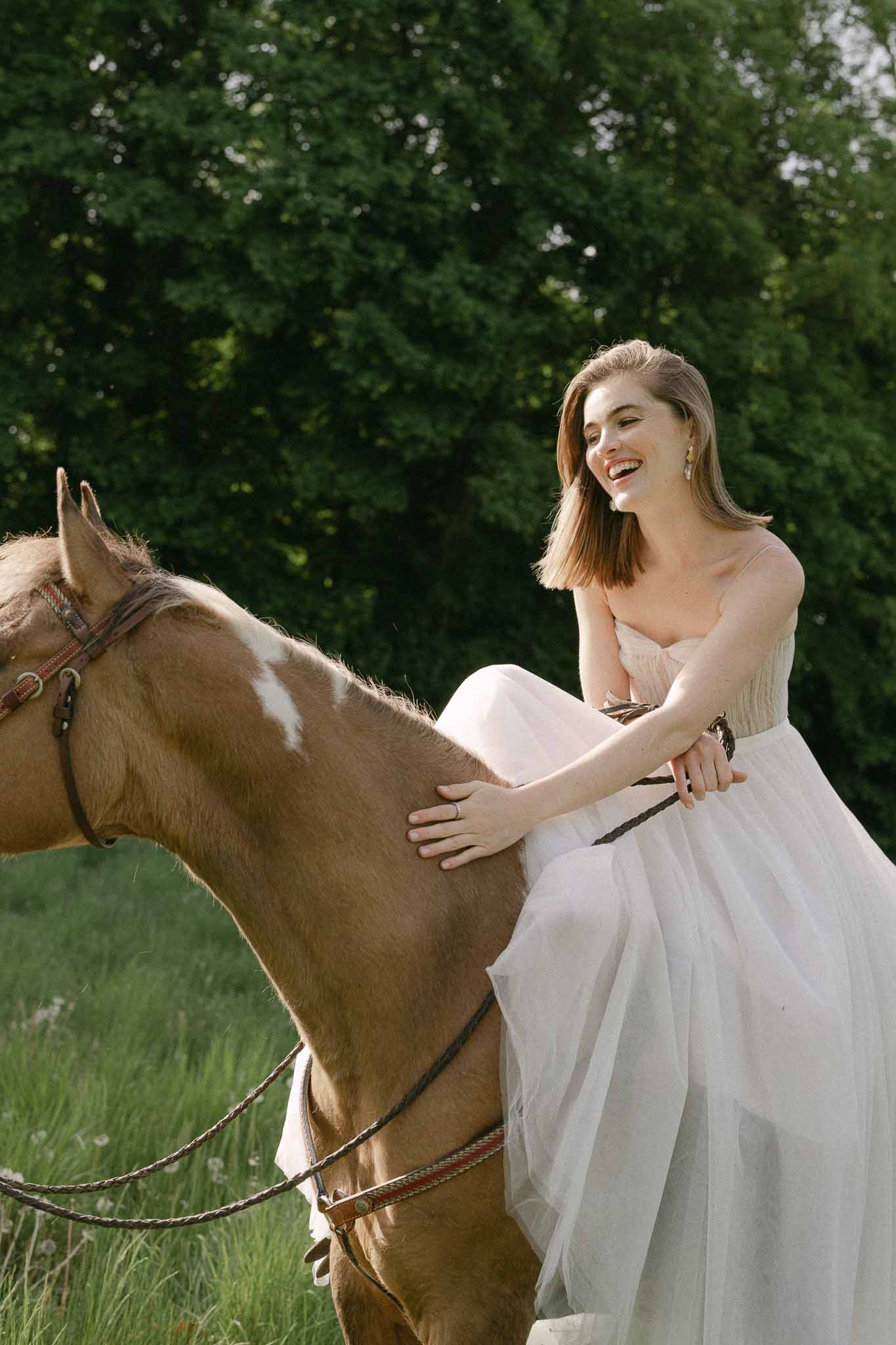 Bride with horse in garden setting for equestrian wedding portrait