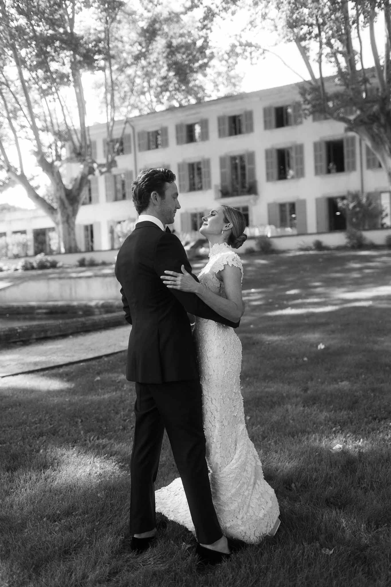 Black and white wedding couple portrait in front of classical manor house with manicured grounds