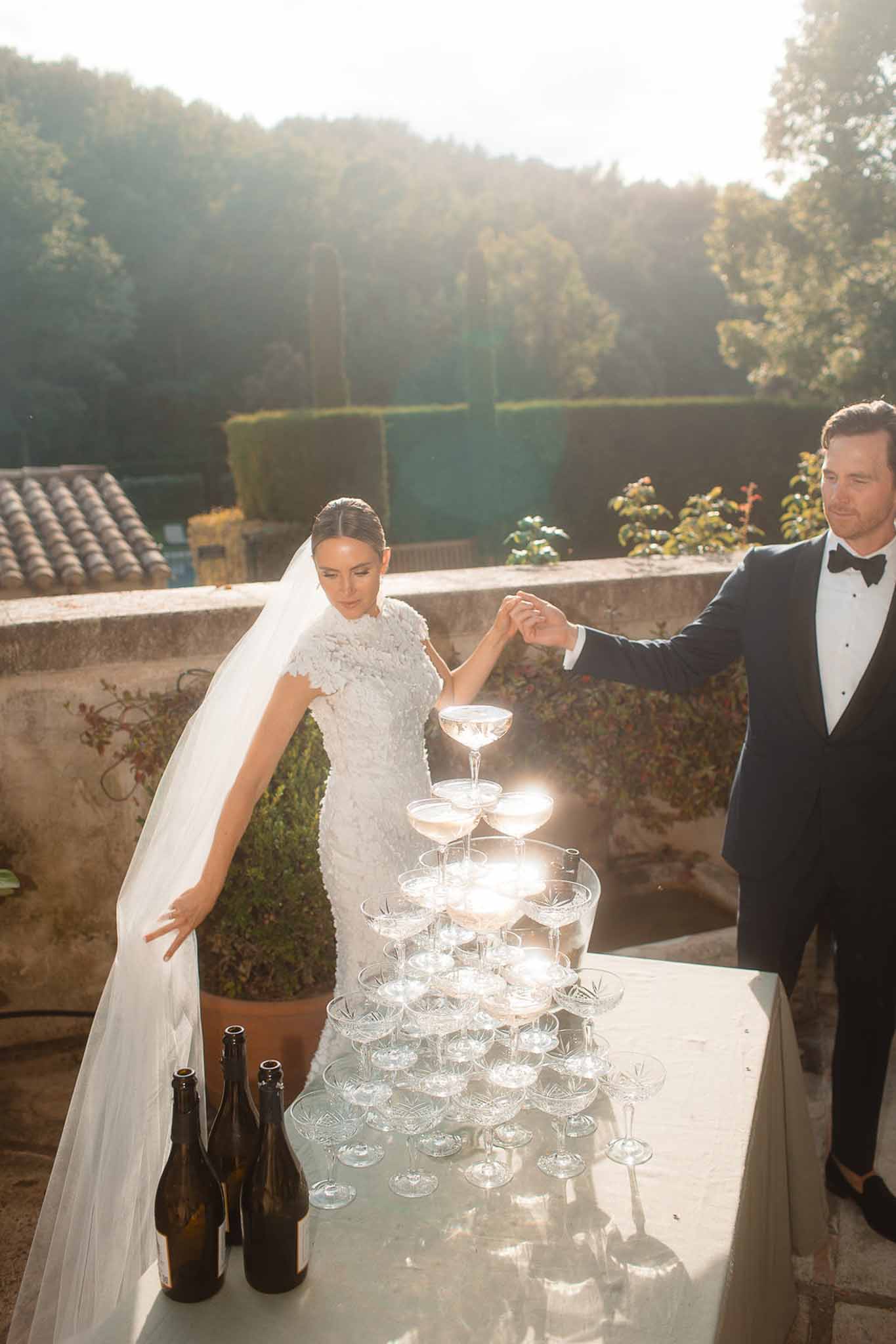 Bride and groom champagne tower ceremony at outdoor garden terrace reception