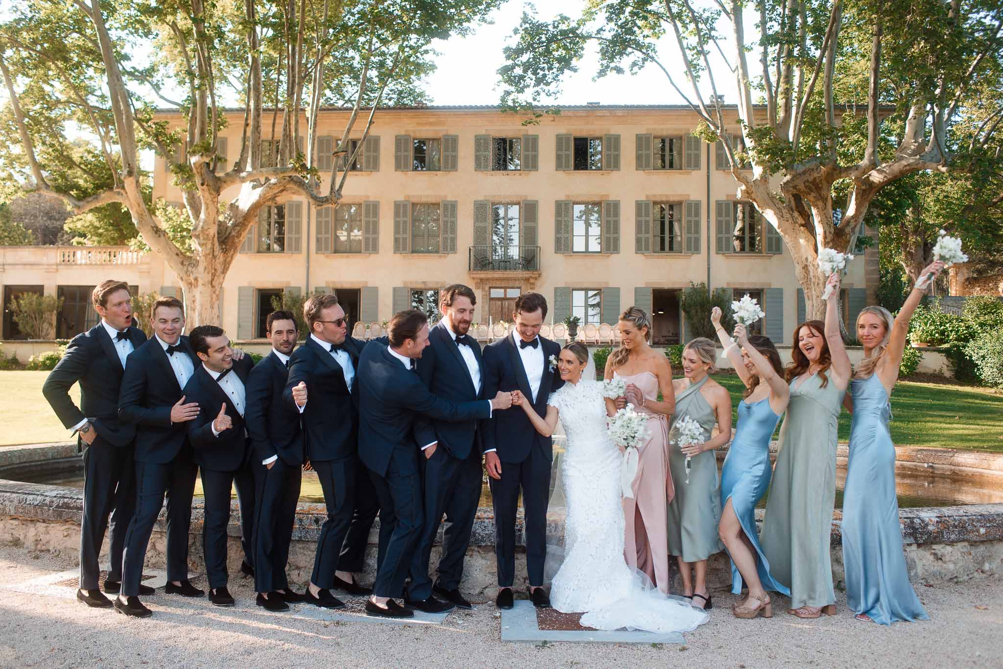 Bridal party group portrait in European villa courtyard with bride, groom, and wedding party