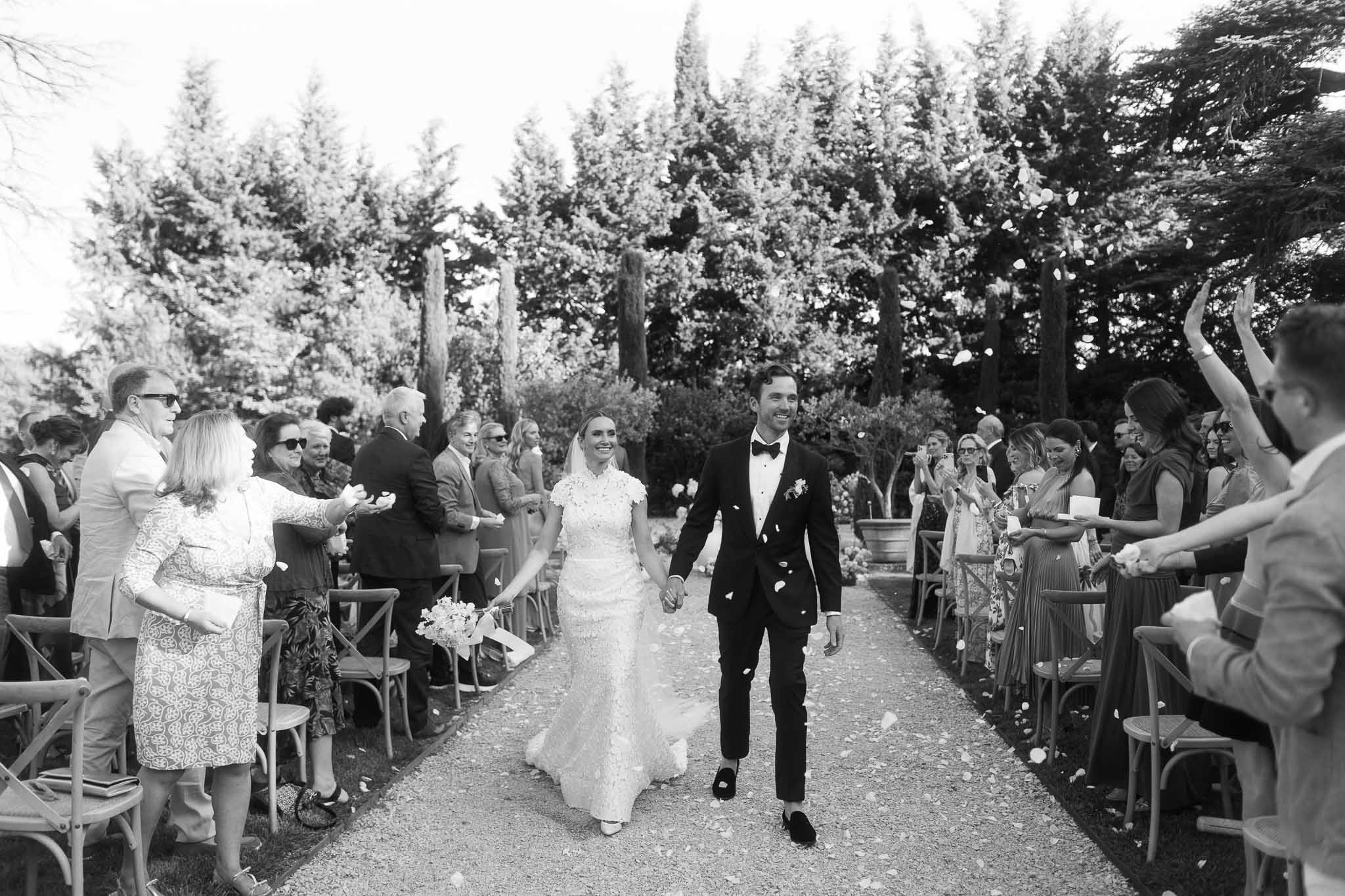 Bride and groom walking down aisle during recessional at outdoor woodland wedding ceremony