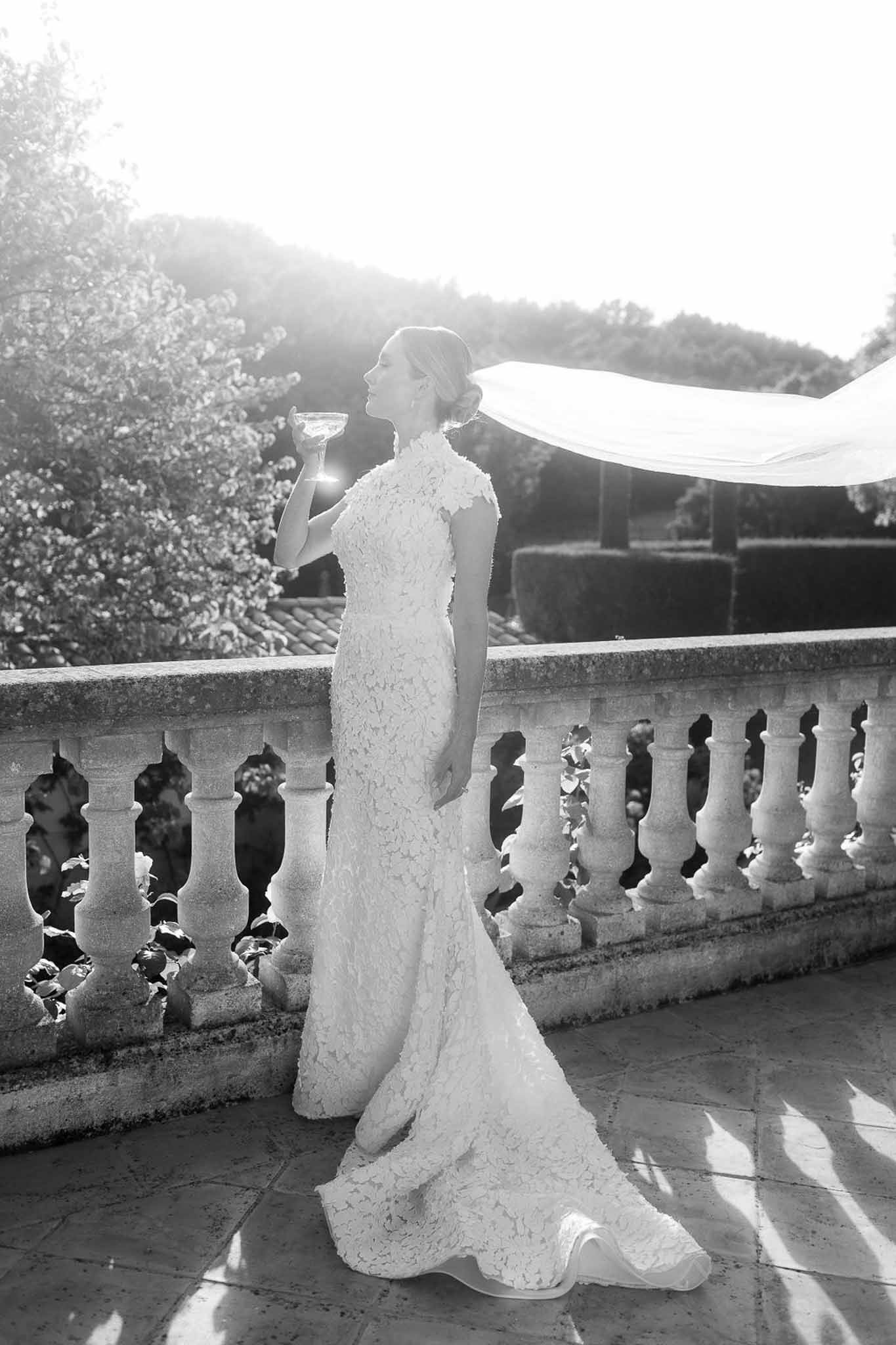Bride in lace wedding dress on stone terrace at formal estate wedding venue