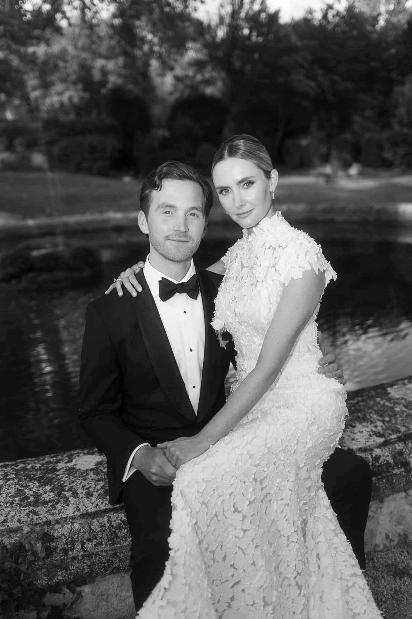 Bride and groom portrait by water feature in garden setting