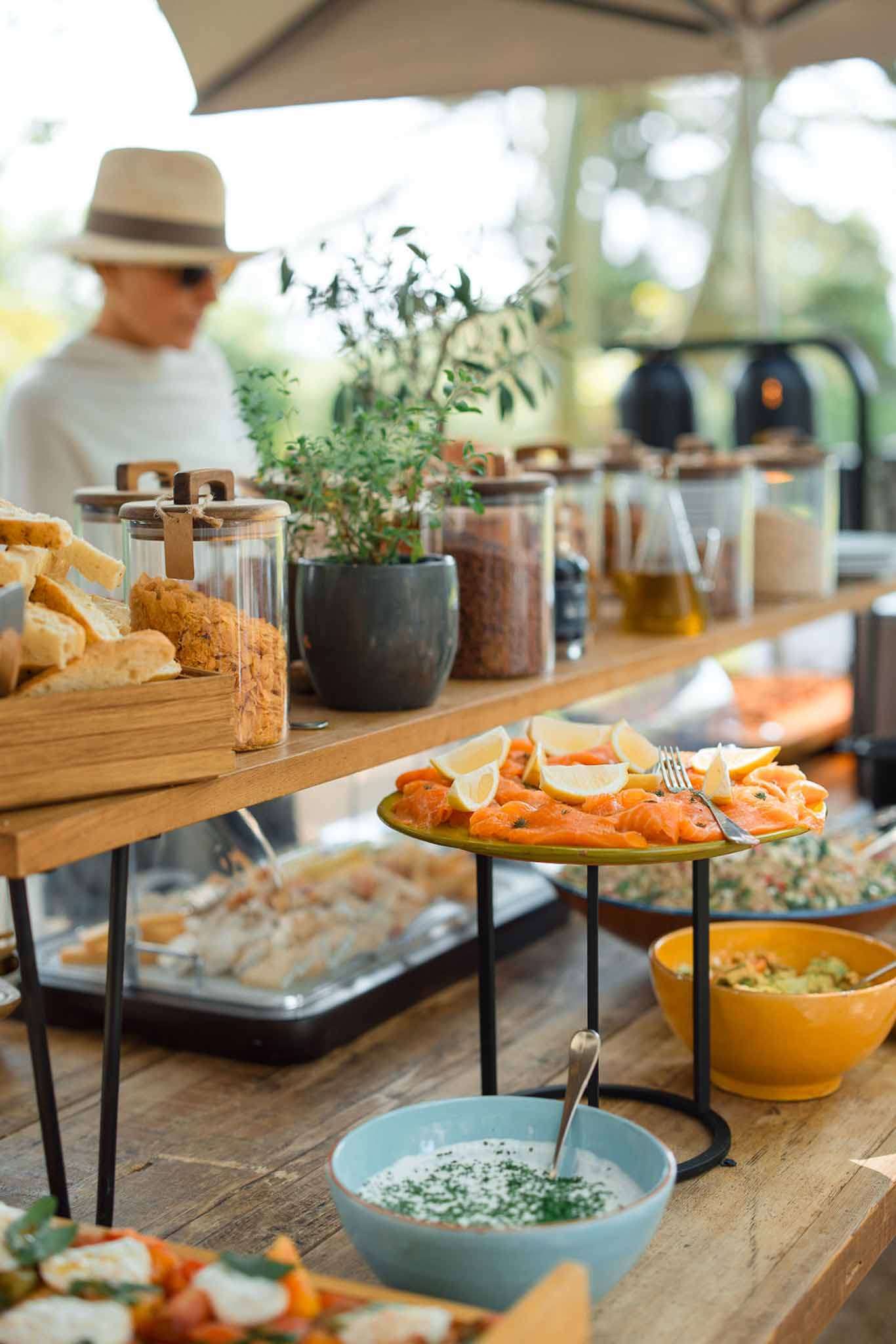 Cocktail hour food display with smoked salmon and appetizers on wooden tables at outdoor wedding venue