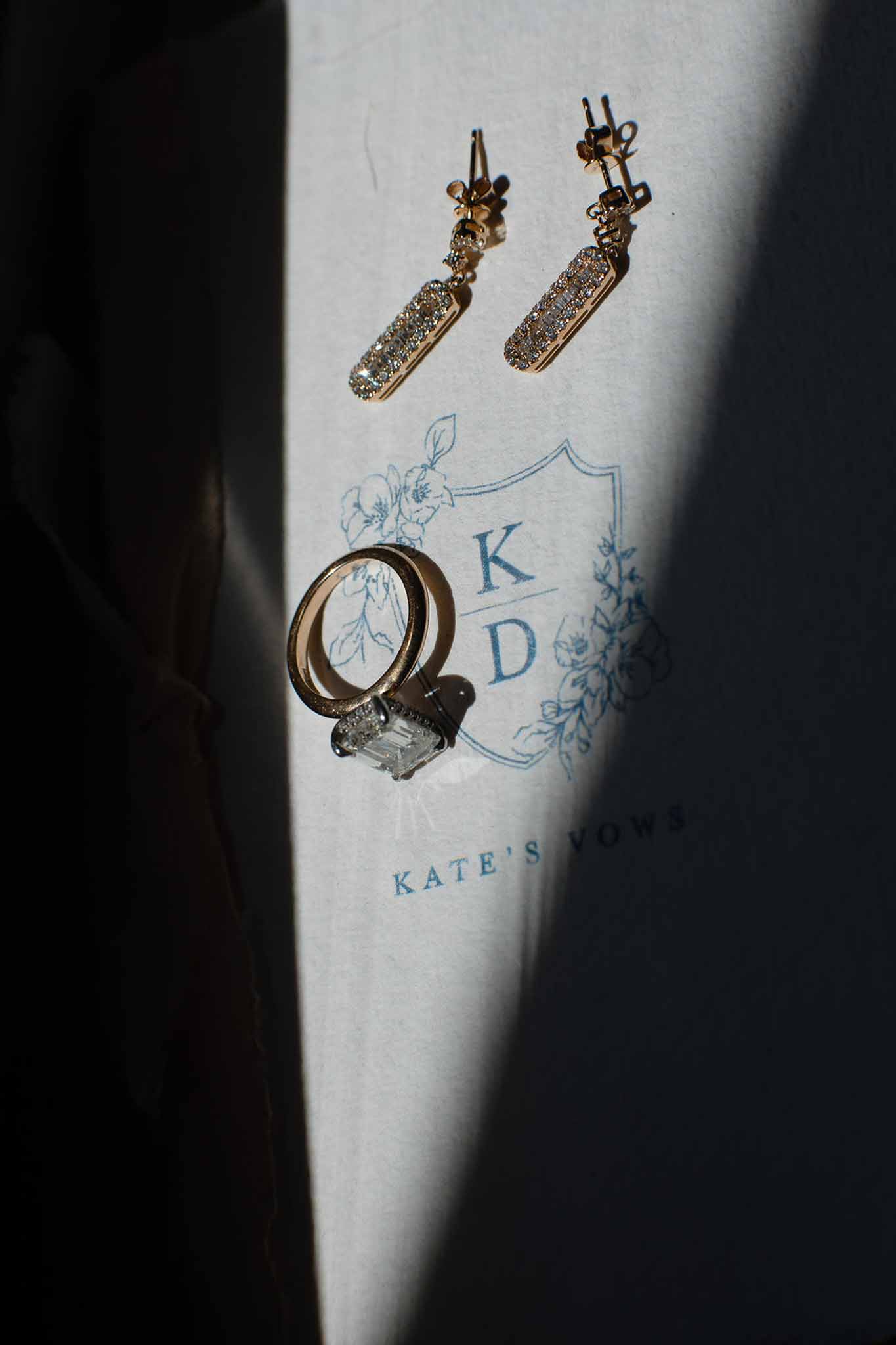 Wedding rings, gold earrings, and botanical stationery flat lay arrangement