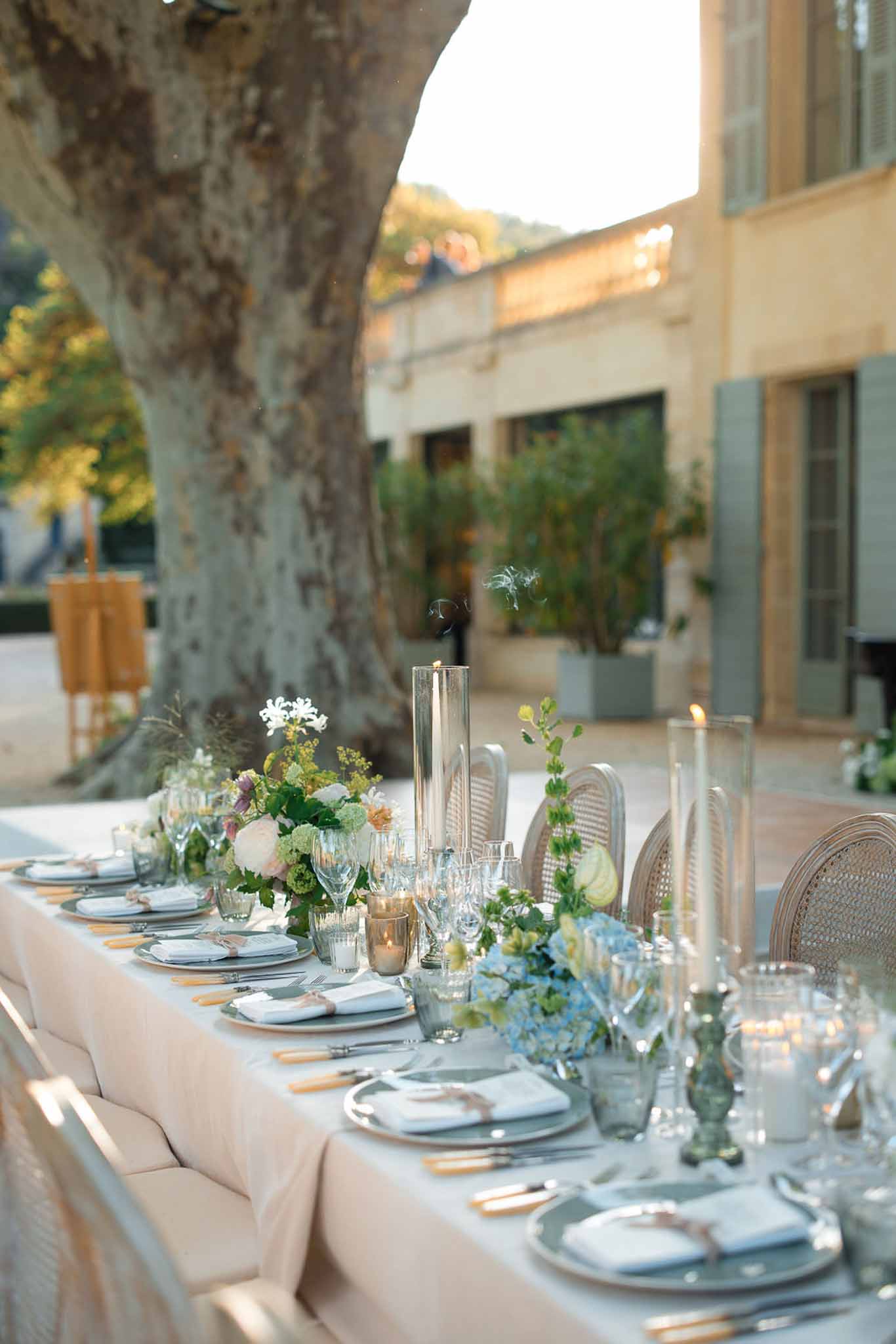 Wedding reception table setting with white florals and gold accents in Mediterranean courtyard
