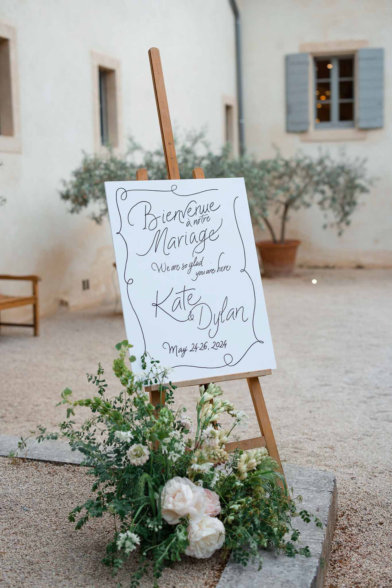 Wedding welcome sign with floral arrangement at Mediterranean courtyard venue