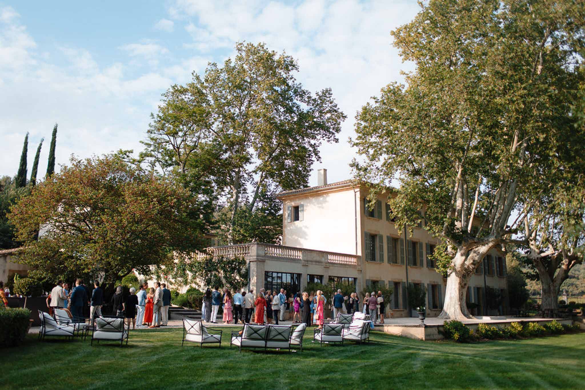 Cocktail hour reception with guests mingling on manicured lawn at Italian villa wedding venue