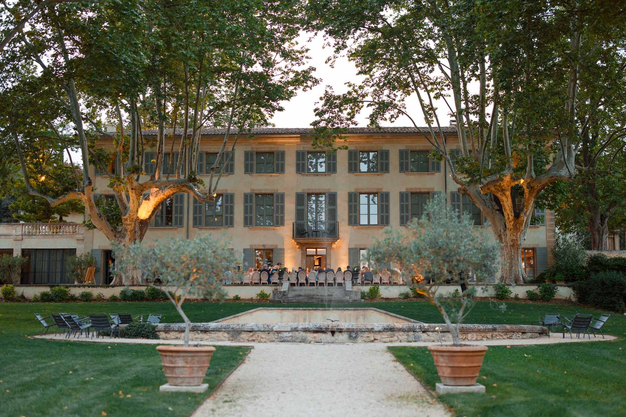 Evening reception dinner on villa terrace with formal Italian gardens and reflecting pool