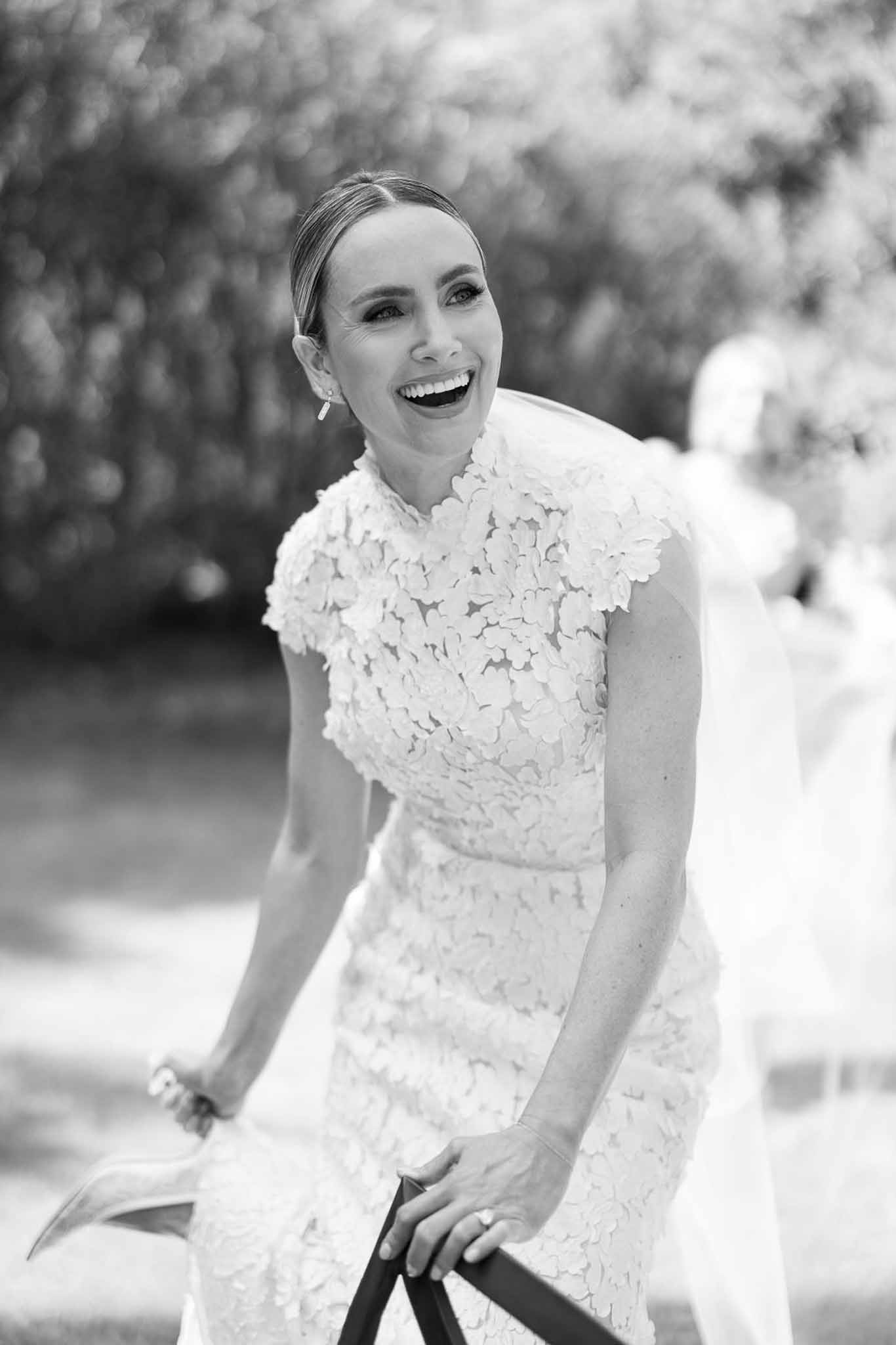 Smiling bride in lace wedding dress portrait in garden setting