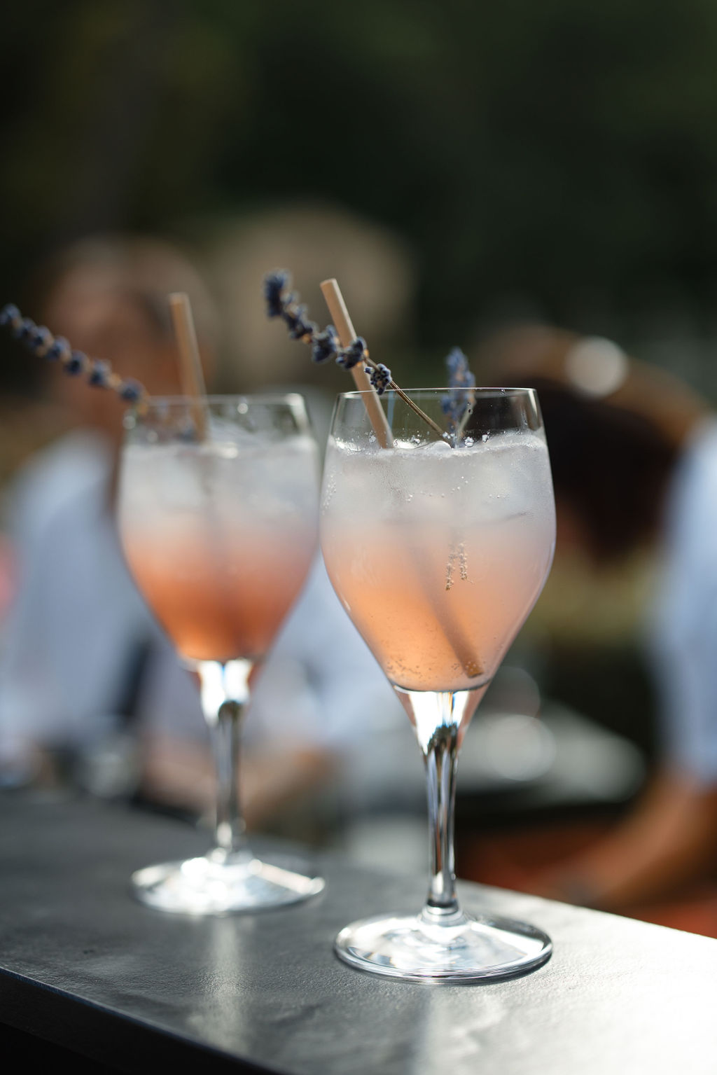 Peach cocktails with lavender garnish at outdoor wedding cocktail hour