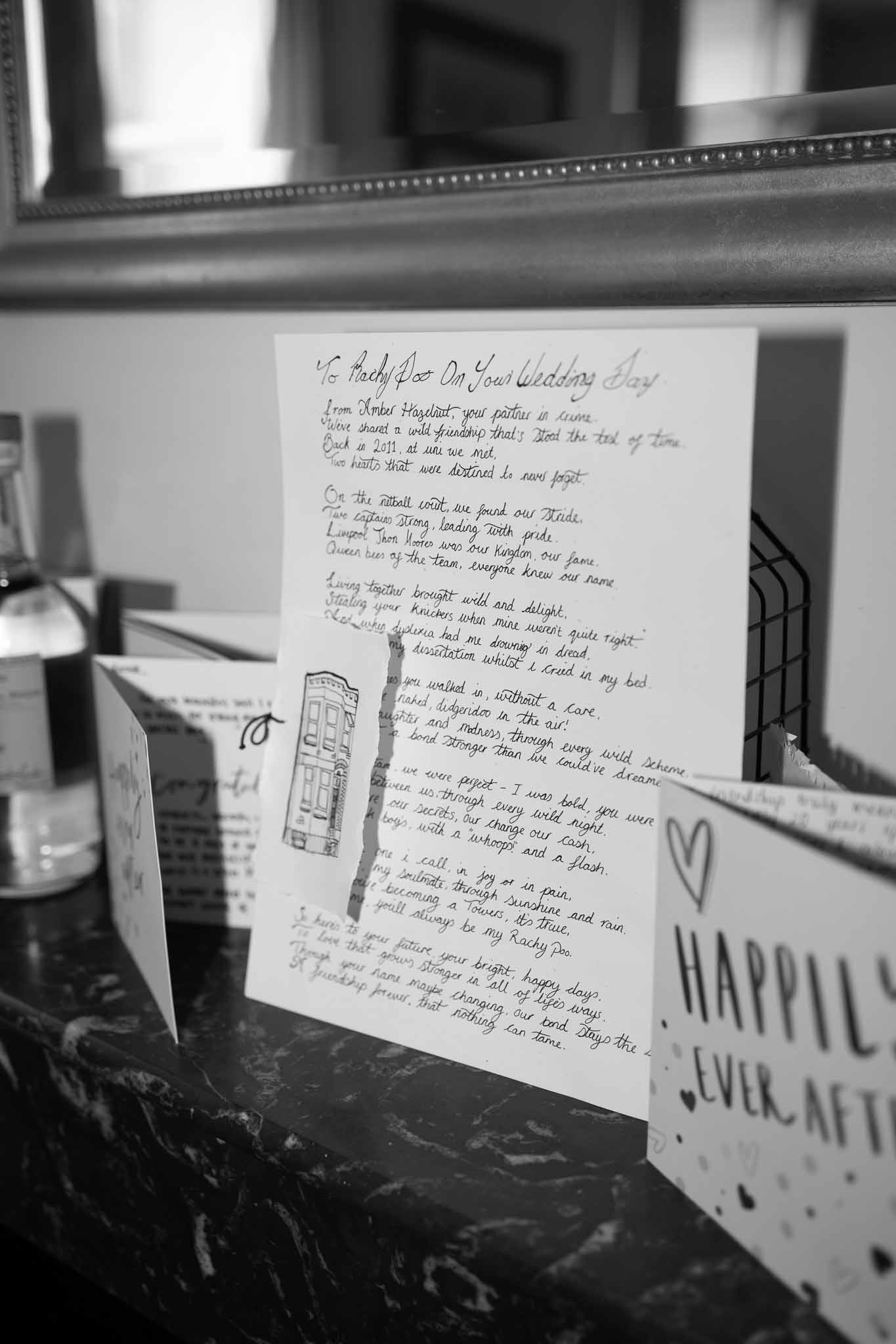 Handwritten friendship poem and wedding day cards on dark marble surface in getting-ready room in B&W