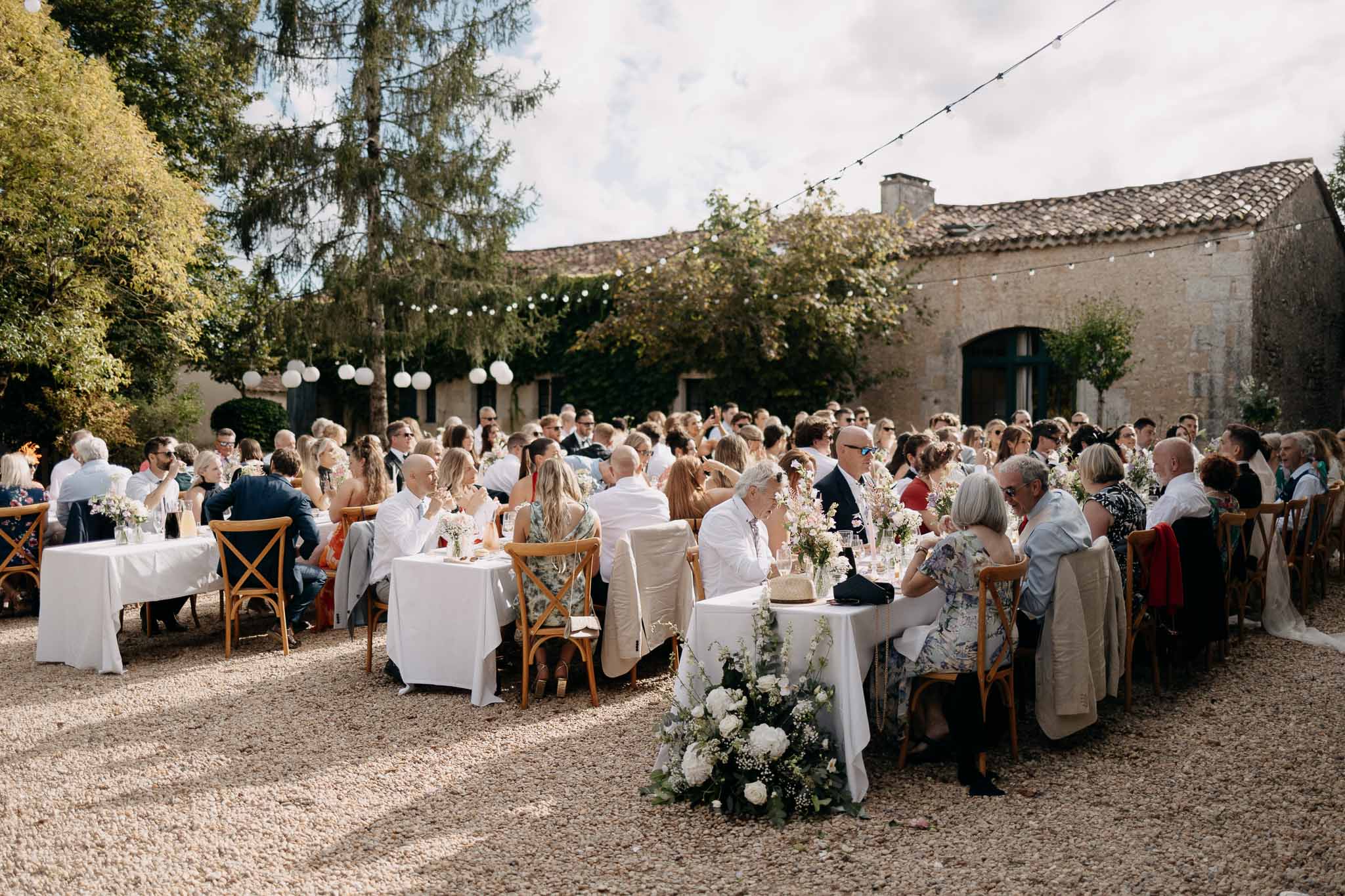 Wedding reception table setting in the French countryside with white roses