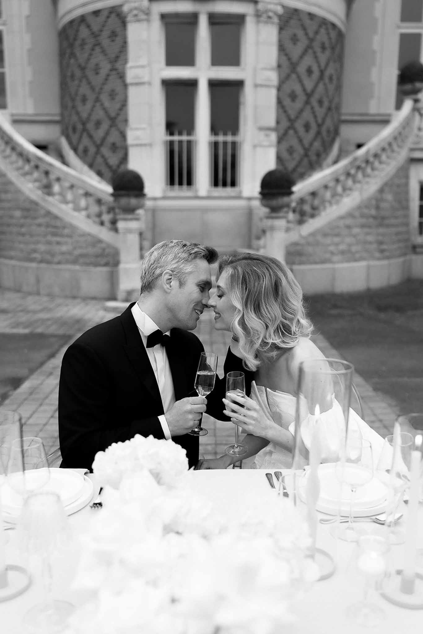 Black and white photo of wedding reception table setting with white roses