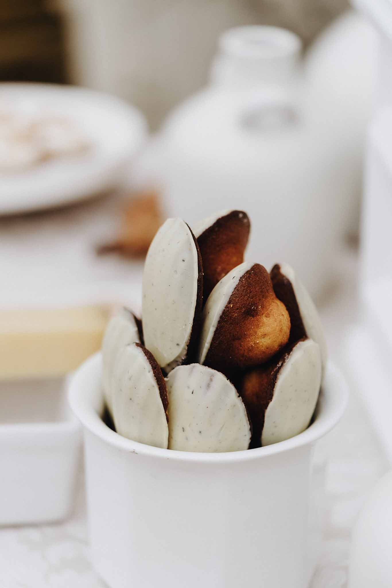 Chocolate-dipped madeleines in white ceramic cup at reception dessert station