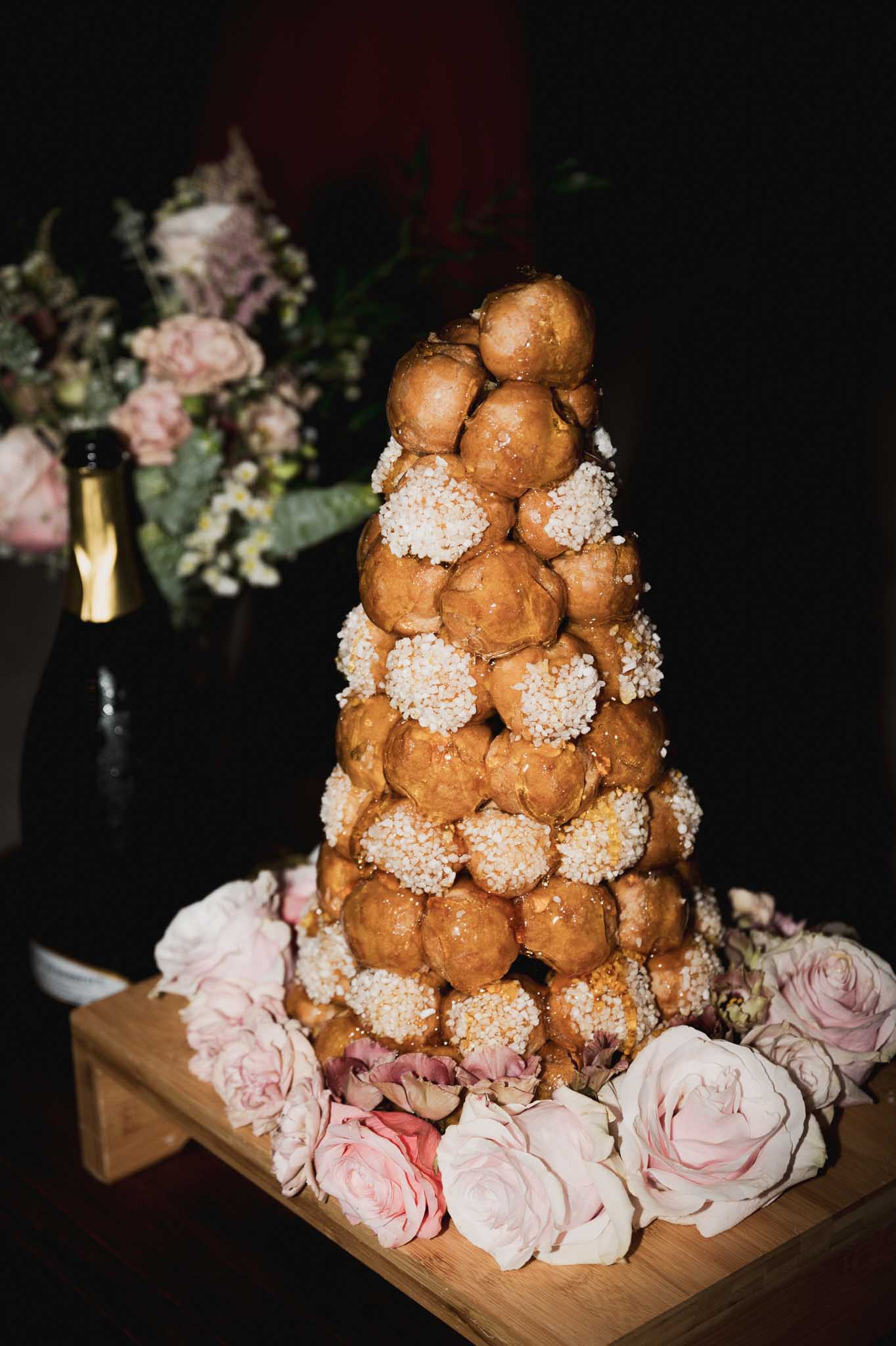 Croquembouche wedding dessert with pink roses at French wedding reception