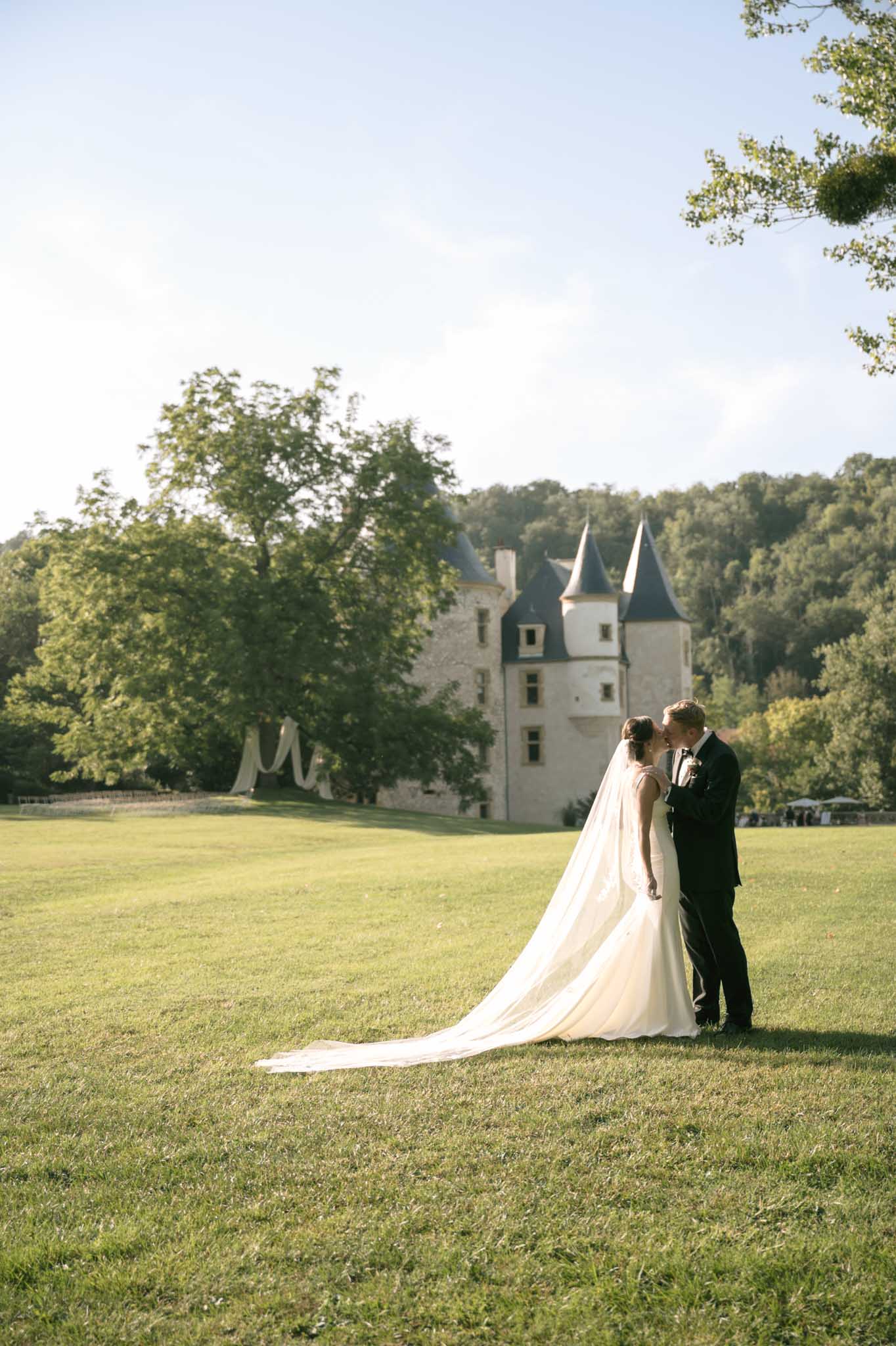 Bride and groom portrait on château grounds with historic turrets in background