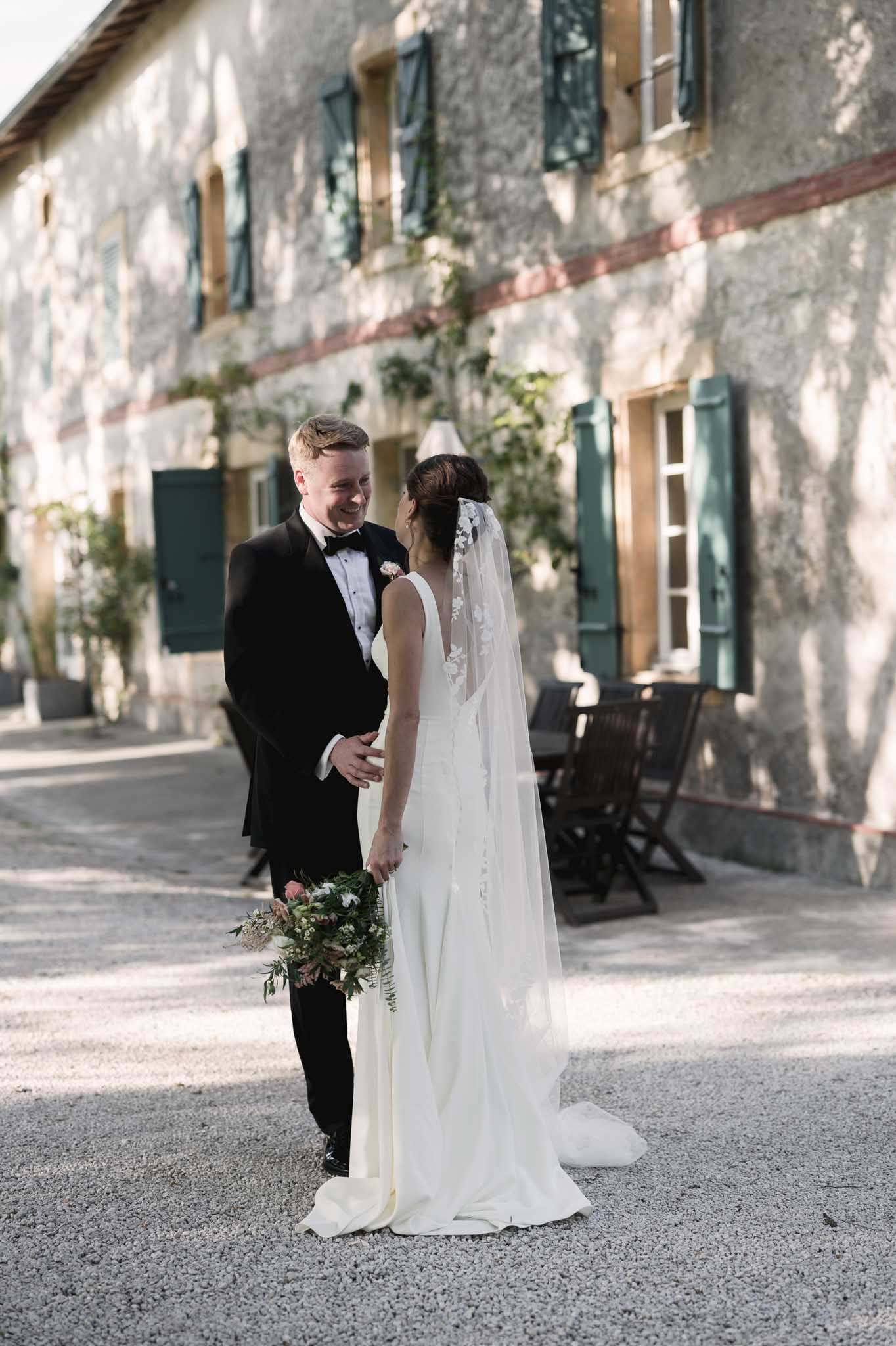 Bride and groom portrait in historic stone courtyard with ivy-covered architecture