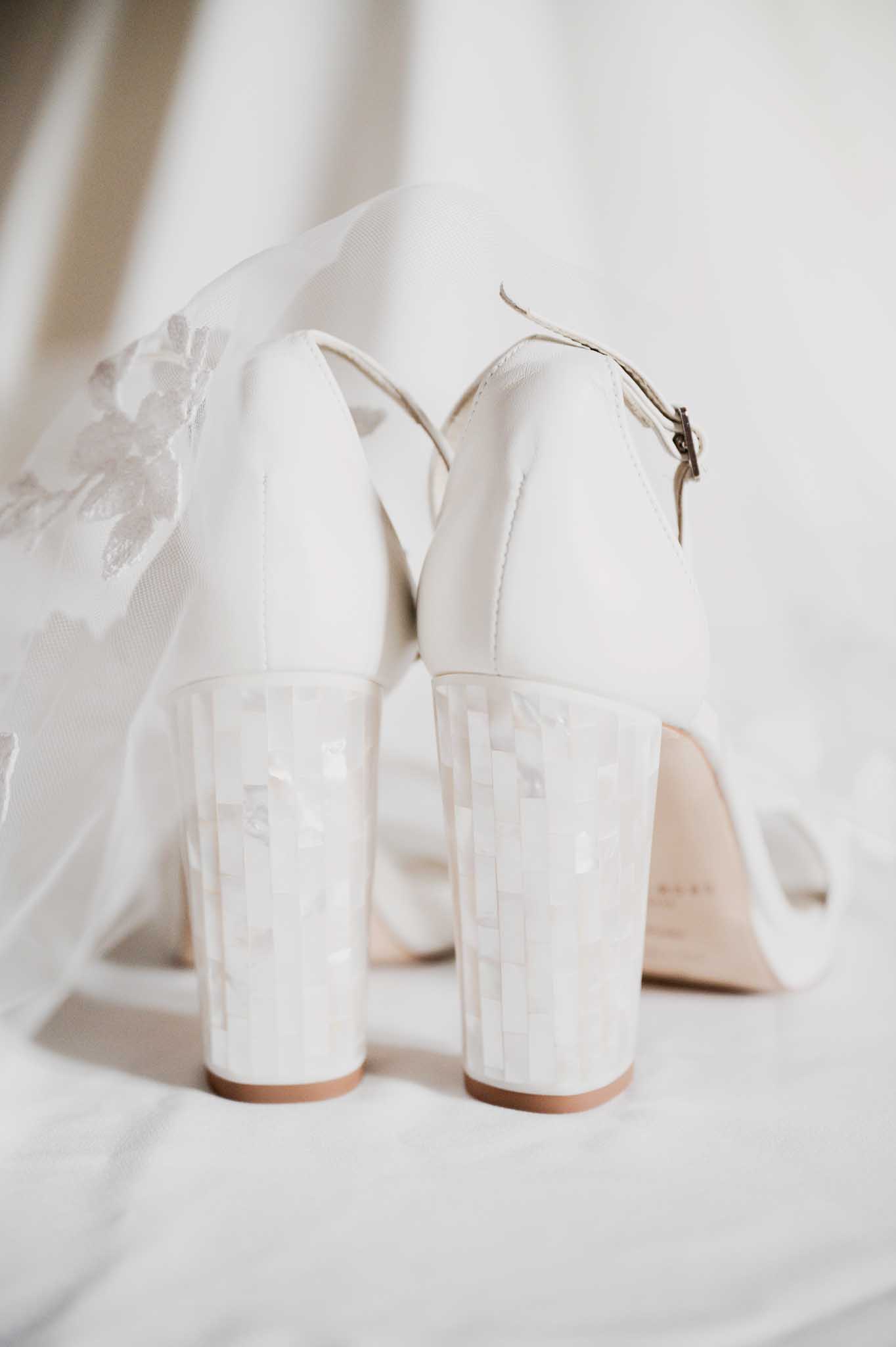 Bride's ivory wedding shoes with ankle straps and embroidered veil during getting ready preparations