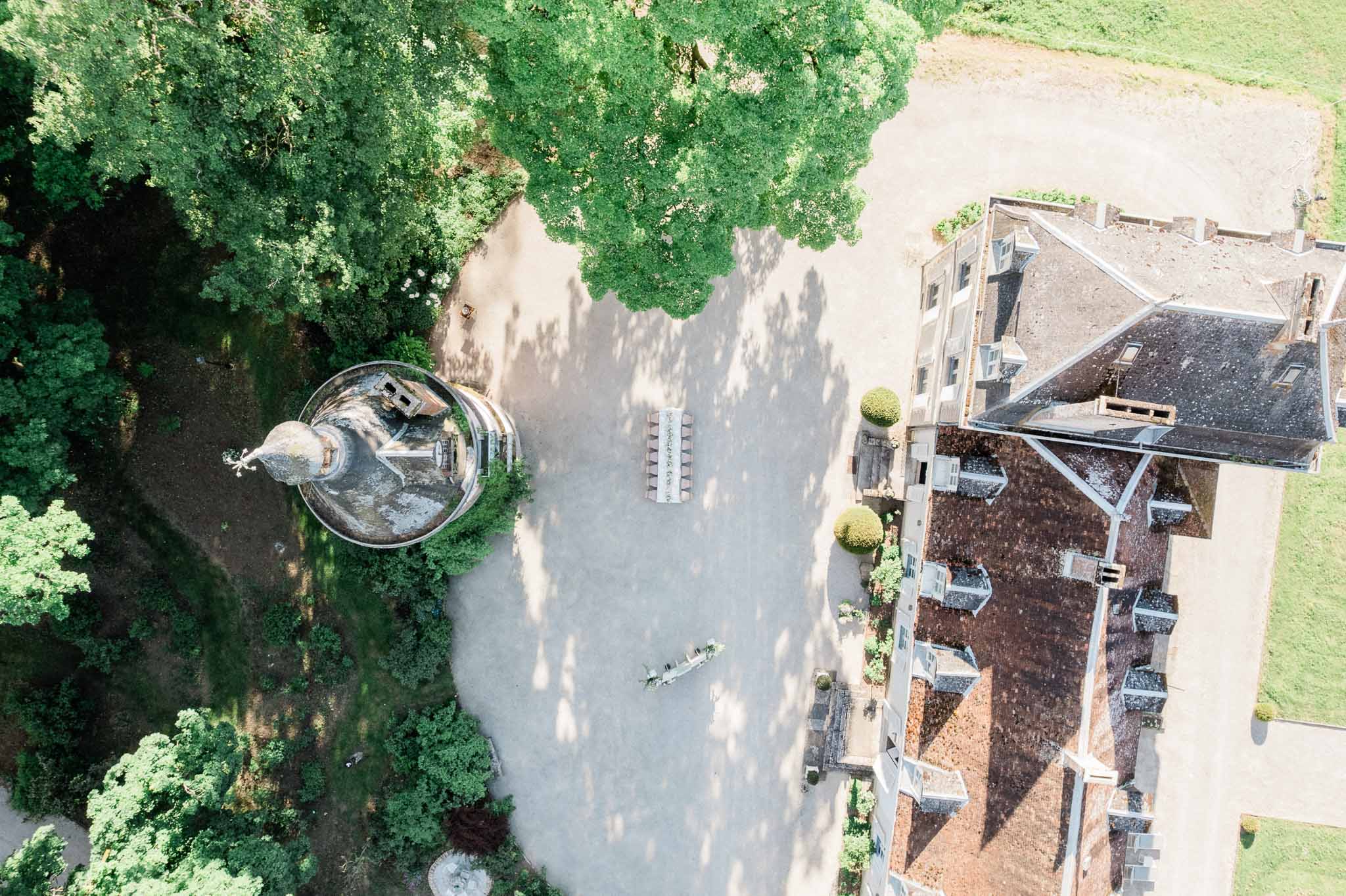 Aerial view of historic stone château with formal gardens and courtyard
