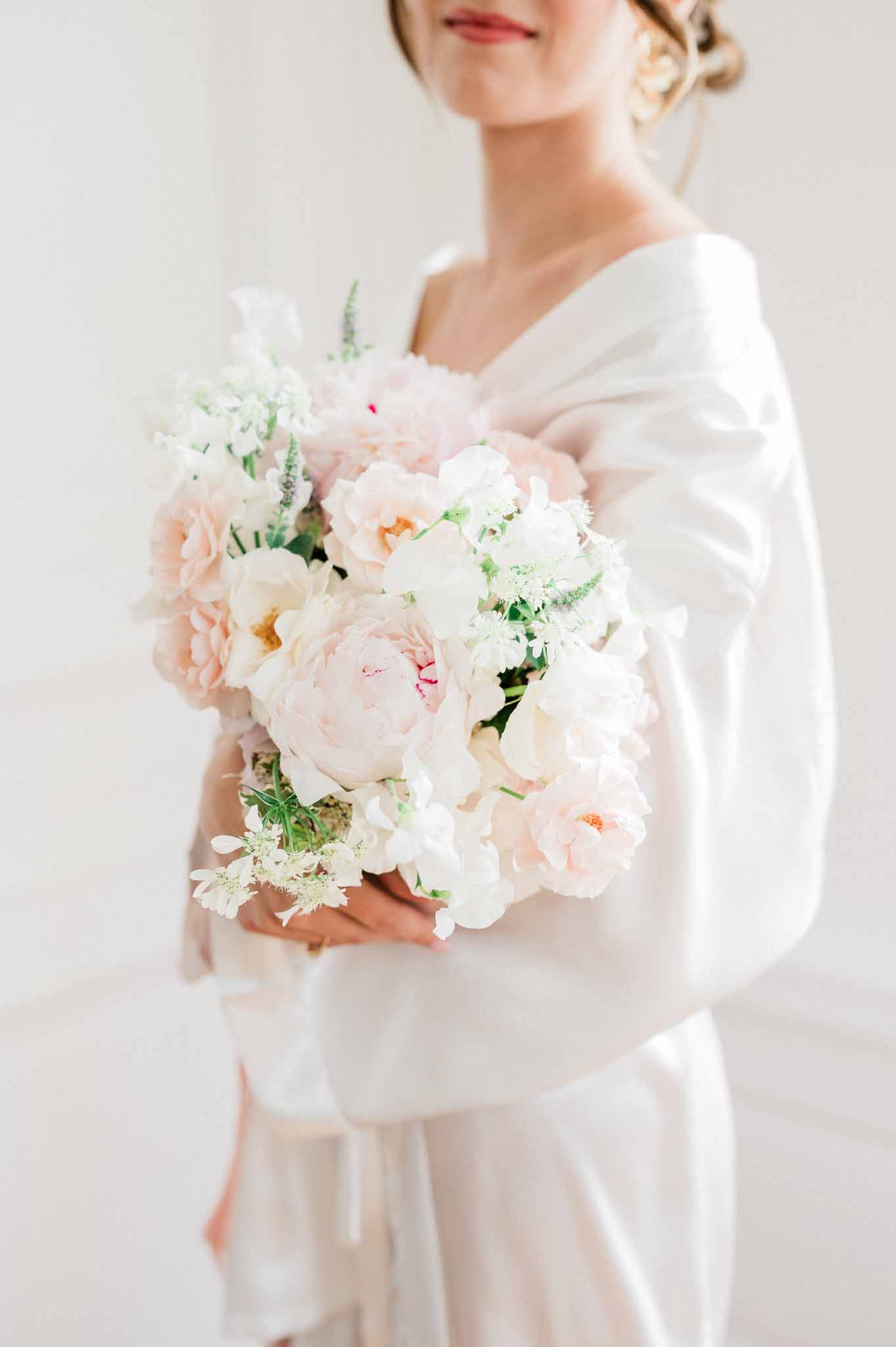 Bride holding blush pink and ivory bouquet in wedding dress portrait