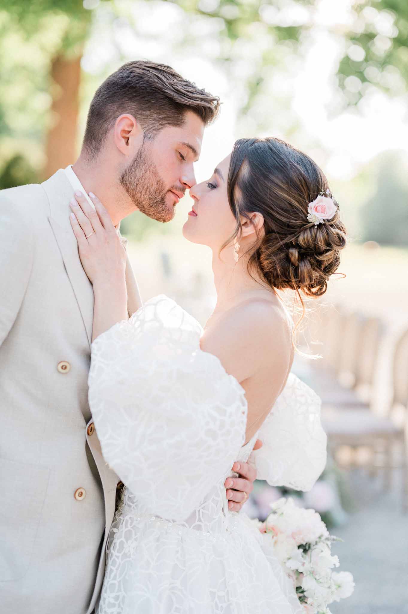 Bride and groom kissing during romantic garden portrait session at outdoor wedding venue
