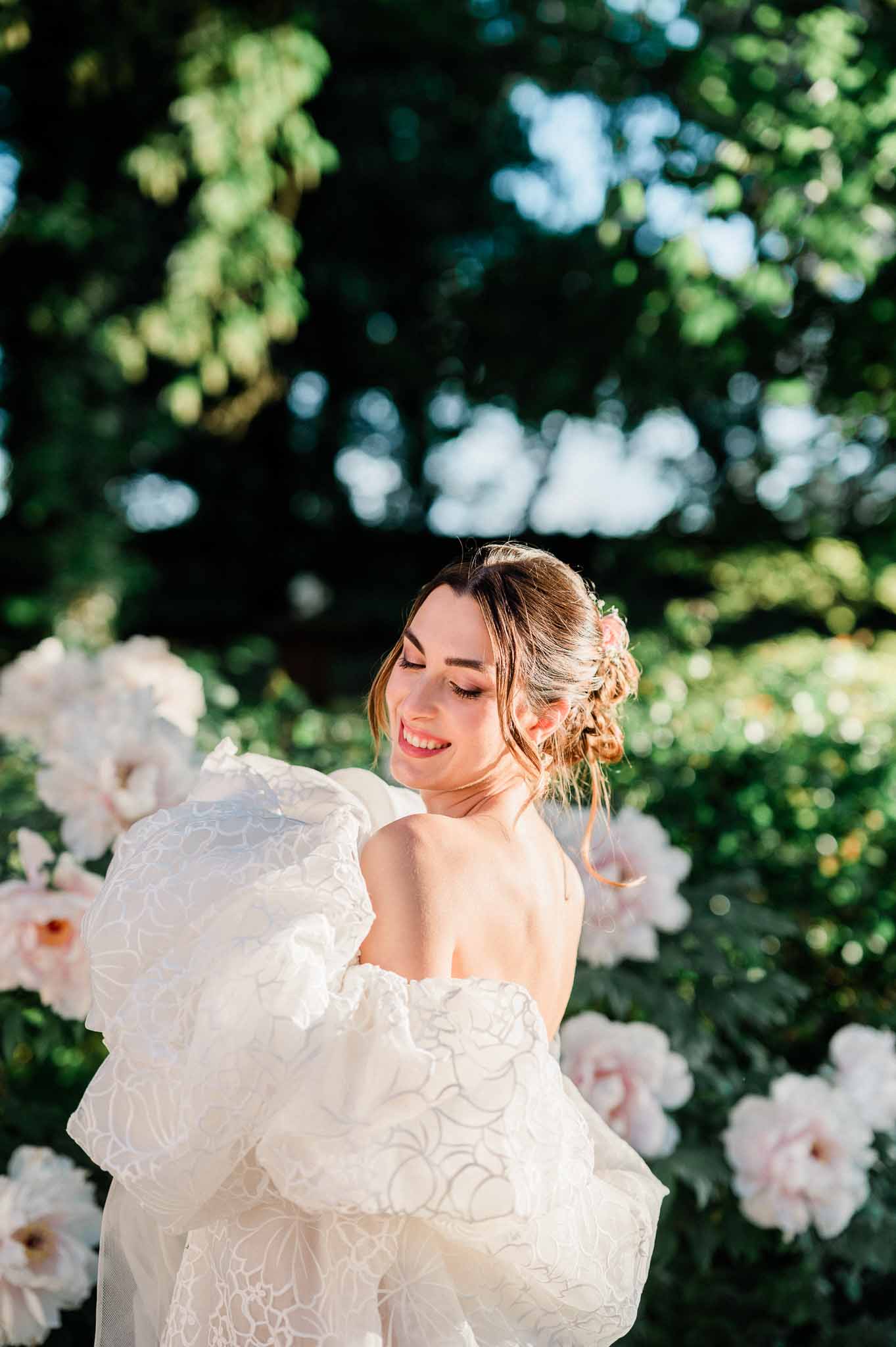 Bride in ivory gown among blooming roses in garden setting