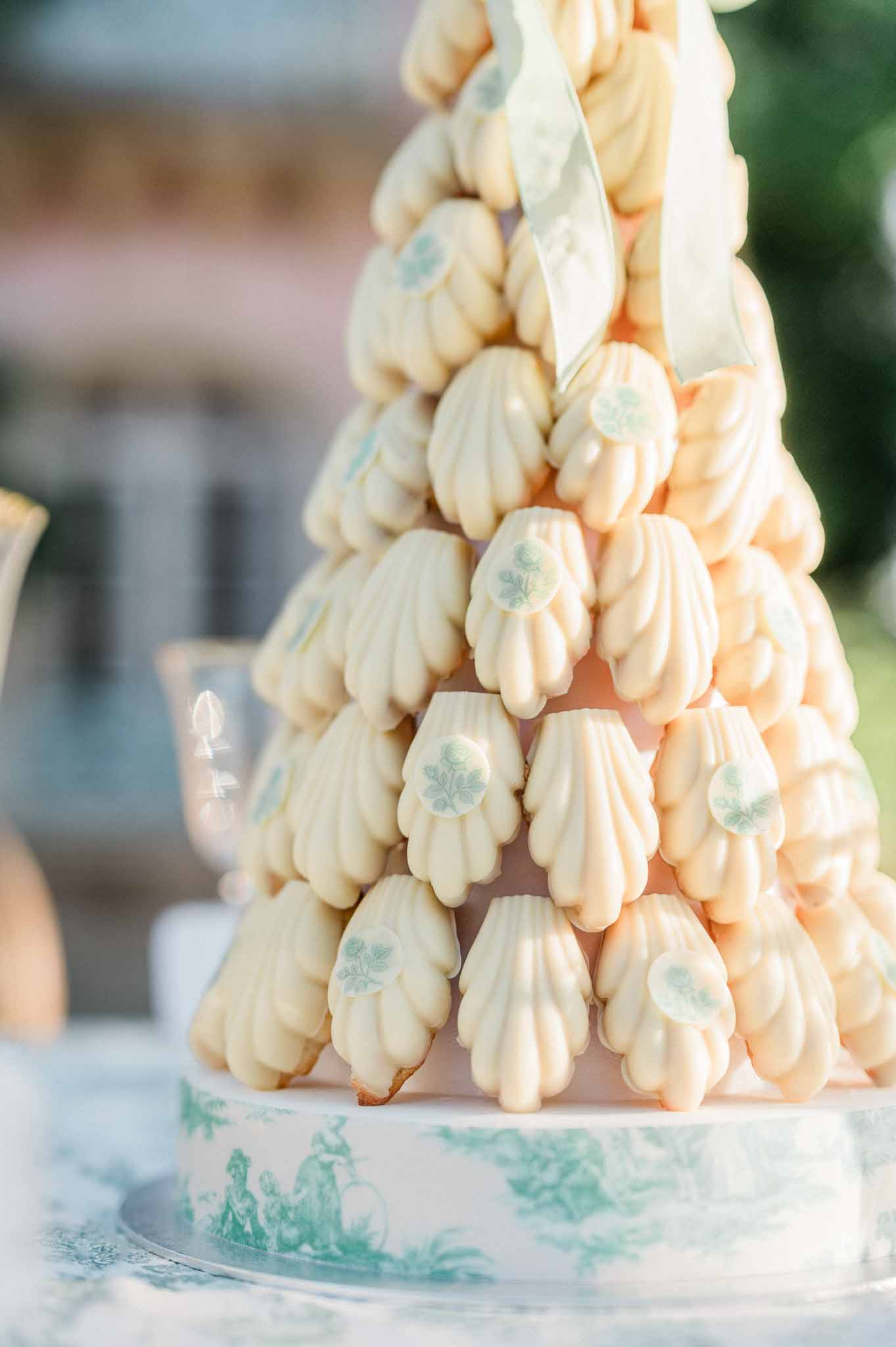 French profiterole tower with sage green details at outdoor wedding reception