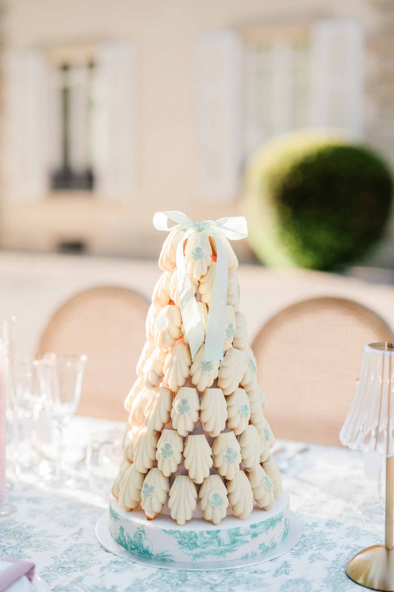 Croquembouche dessert tower with cream puffs and blue floral details at elegant reception table