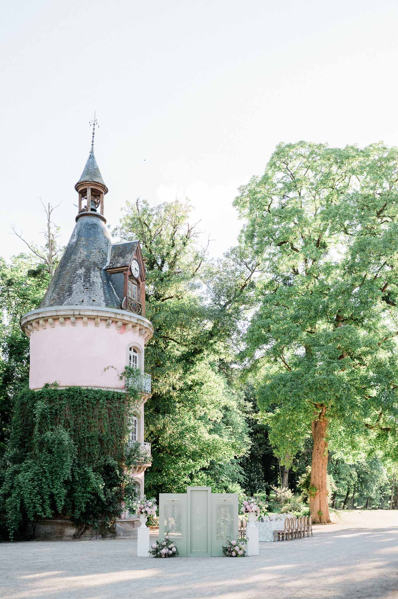 Historic pink tower and ceremonial arch setup at château wedding venue courtyard
