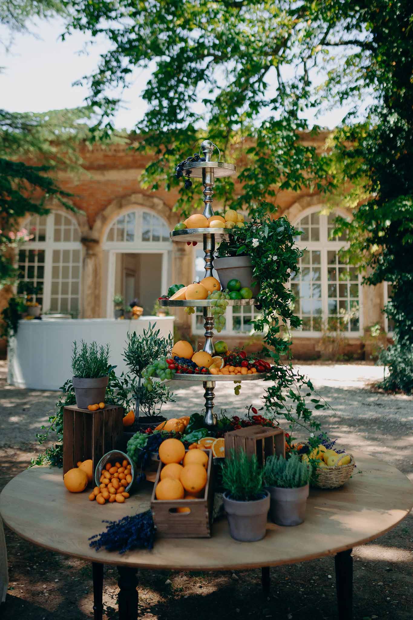 Provencal fruit display with tiered silver stand oranges lemons rosemary and lavender at brick venue