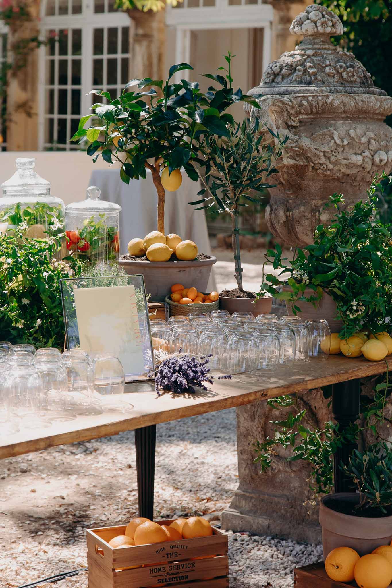 Provencal-styled cocktail drinks station with citrus fruit and infused water in chateau courtyard