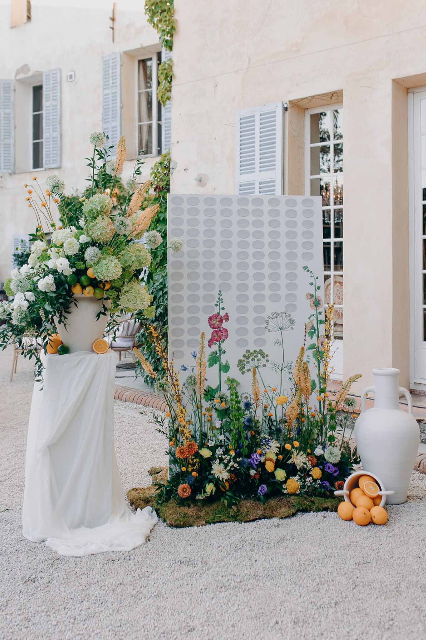 Seating chart with wildflower illustration ground floral installation citrus display and white hydrangea pedestal