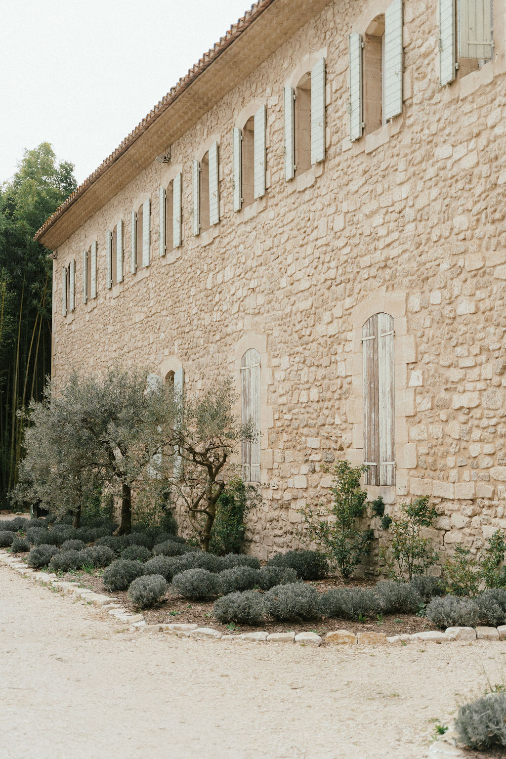 Stone building exterior with Mediterranean landscaping at French country wedding venue