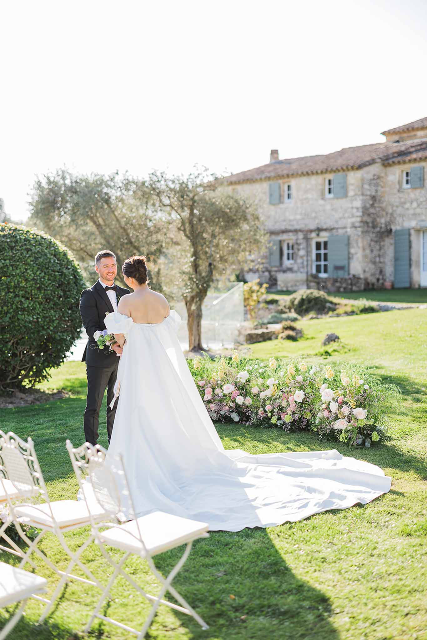 Wedding ceremony at French countryside estate with bride and groom on manicured lawn