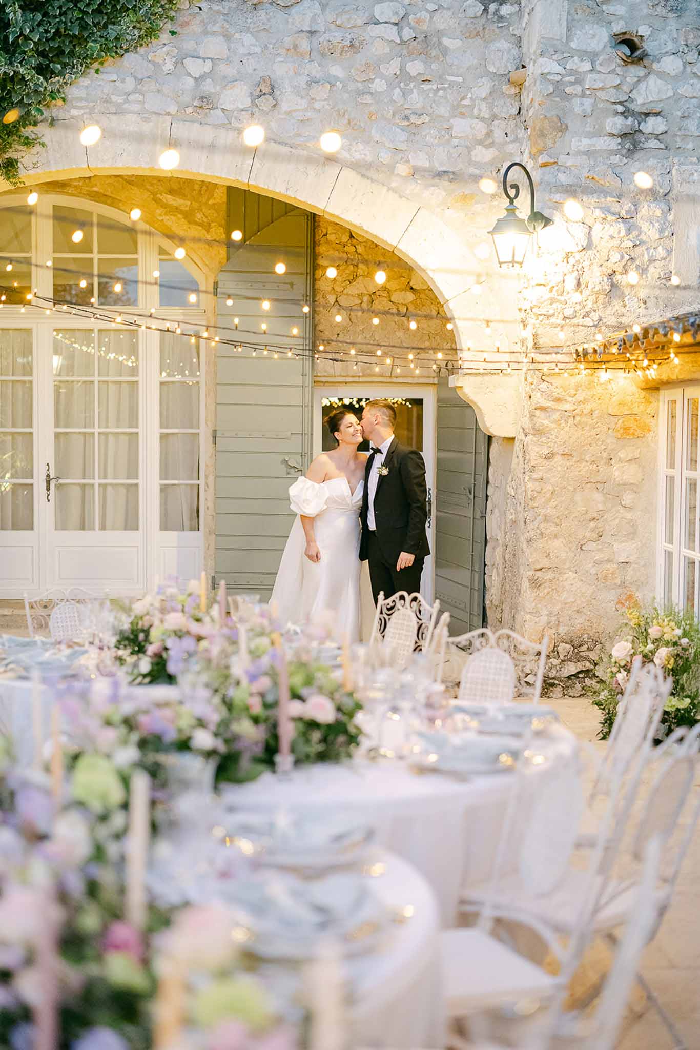 Stone courtyard wedding venue with string lights and reception tables set for evening celebration