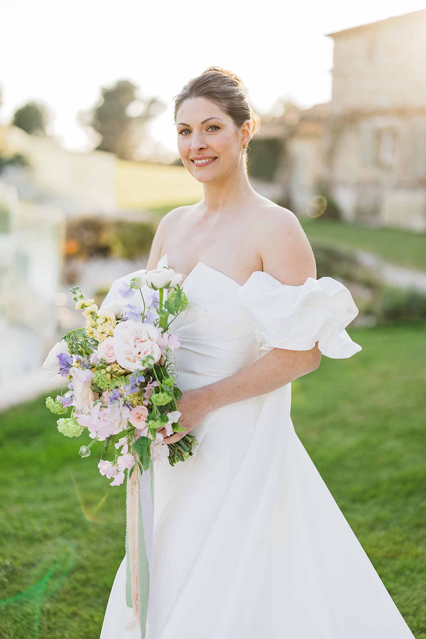 Bride with pink and cream bouquet in formal garden setting