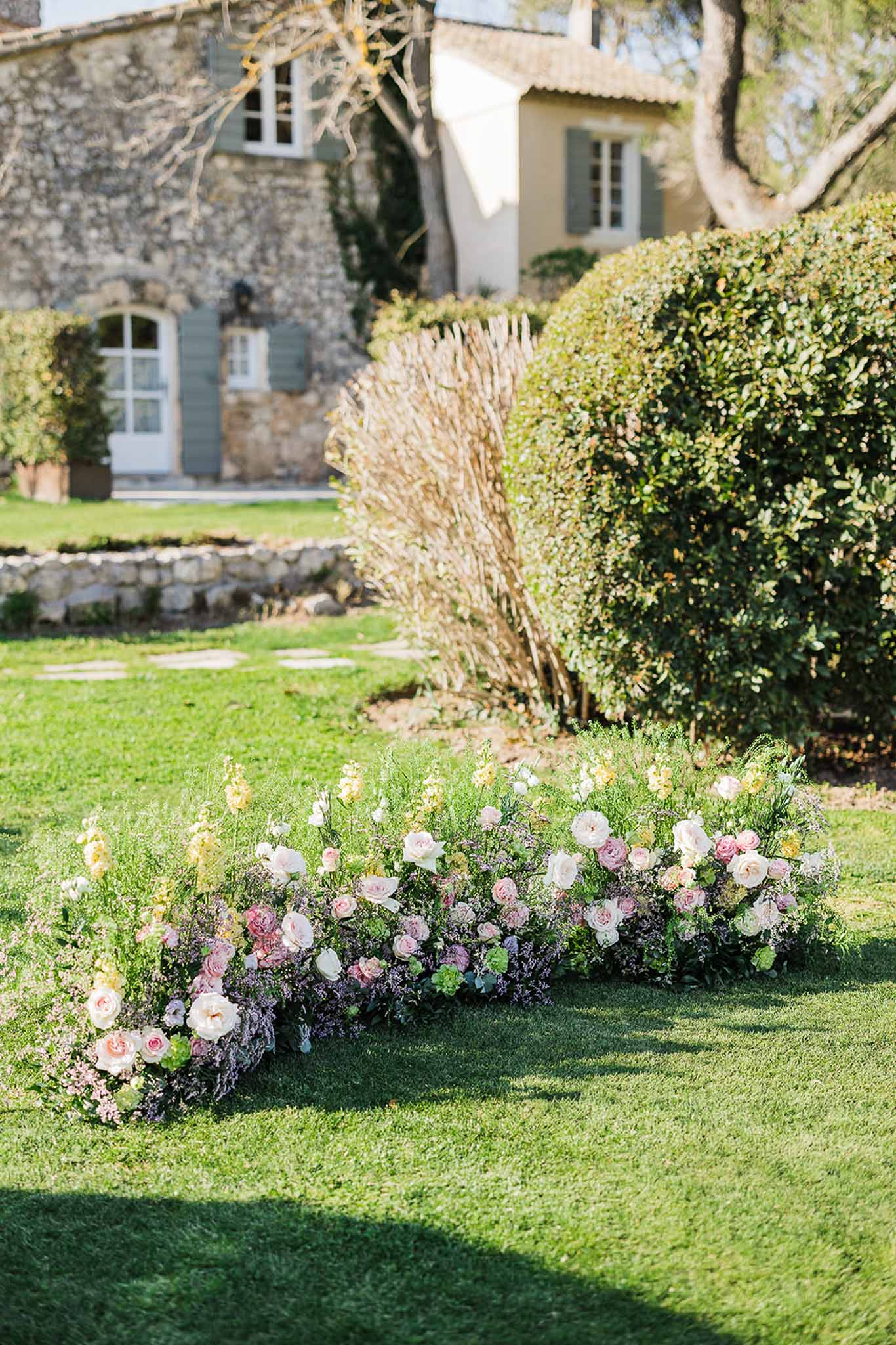 Low garden floral arrangement with roses and greenery at château estate venue
