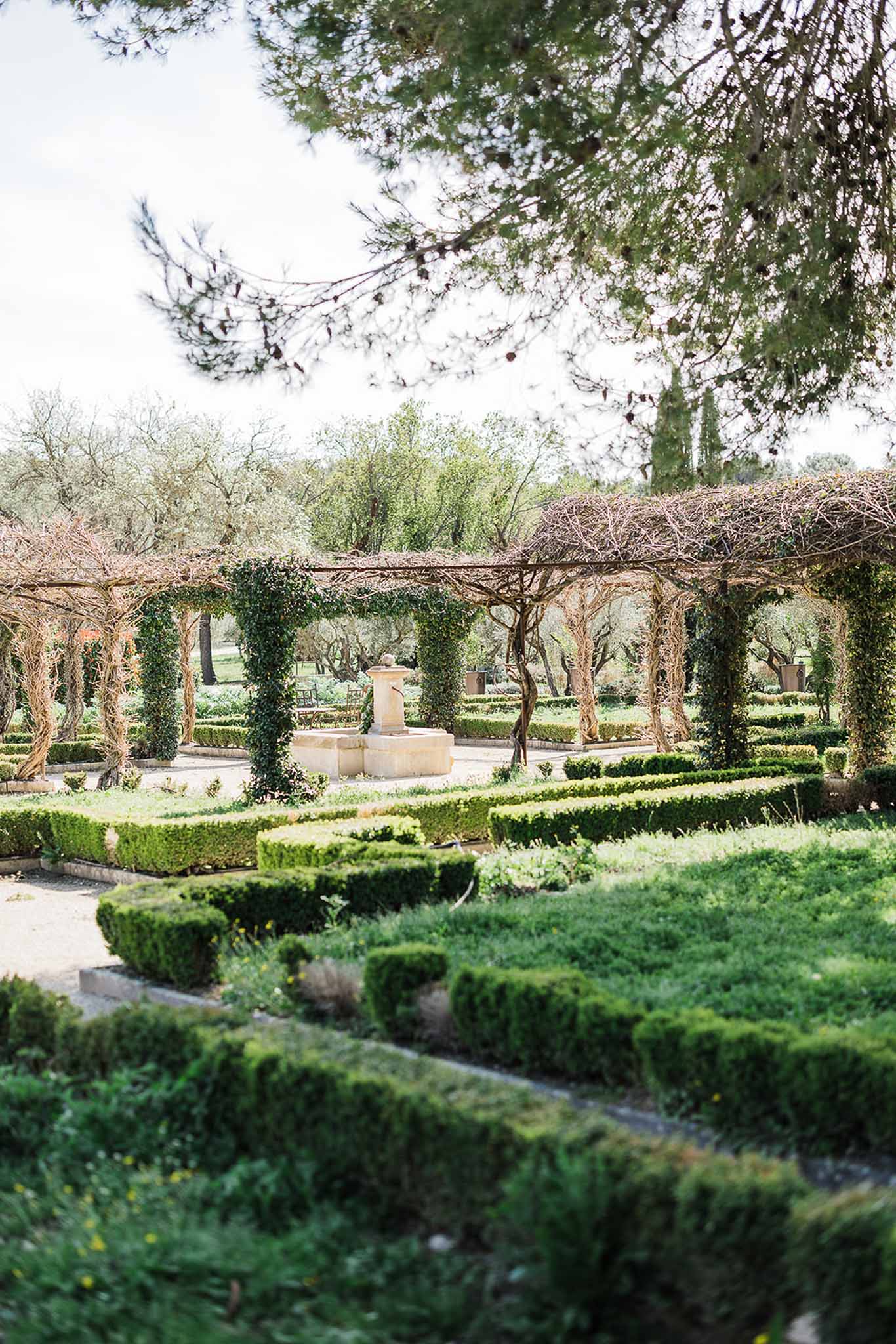 Formal garden with pergola and manicured hedgerows at French venue