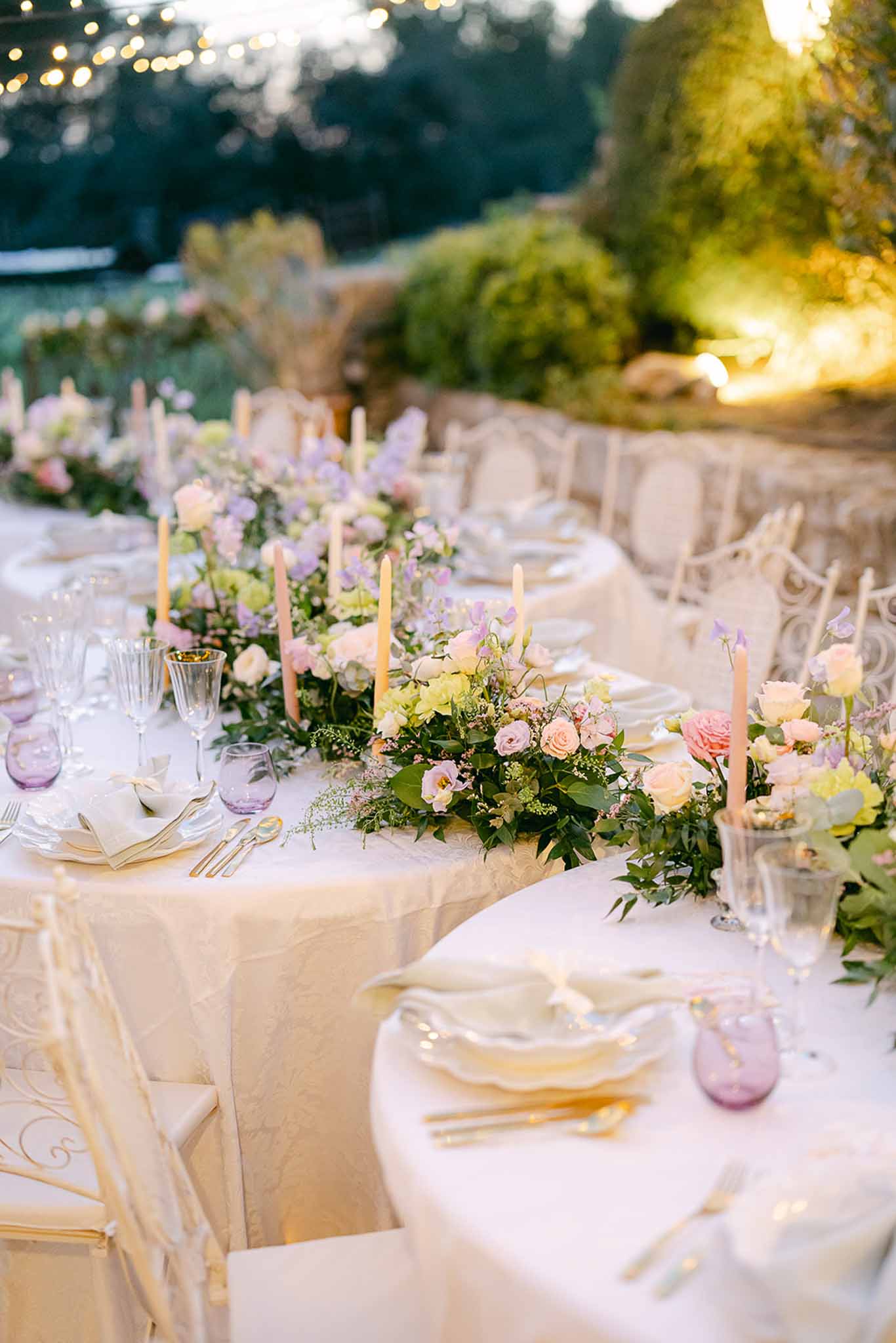 Outdoor reception table setting with peach and lavender florals at garden venue