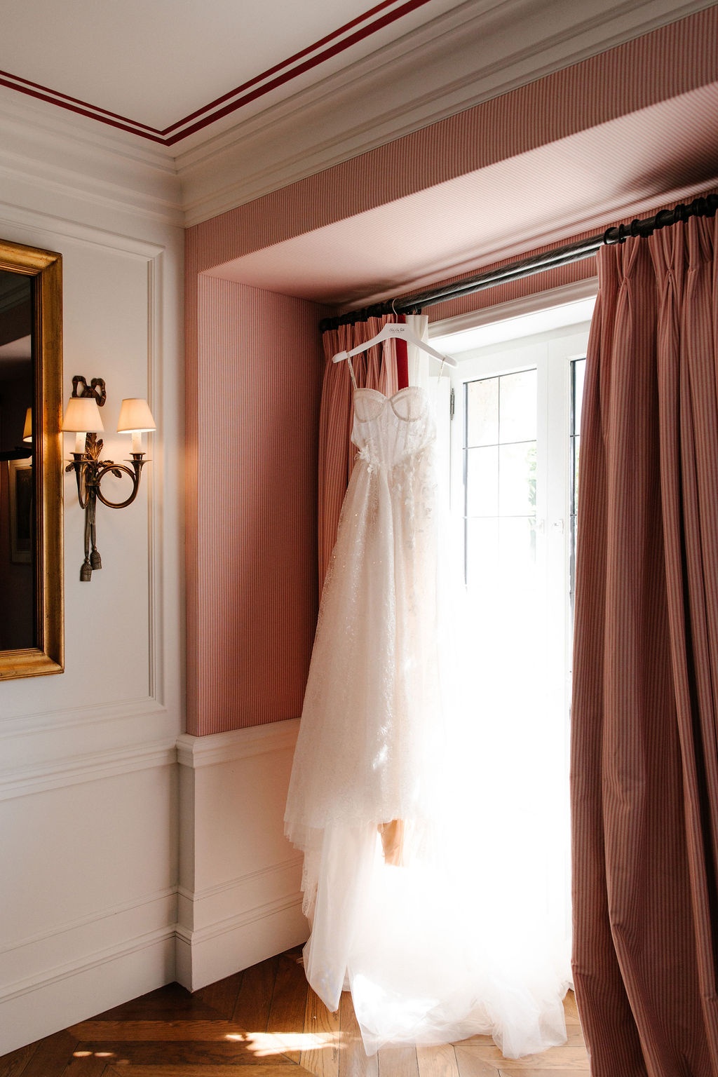 Wedding dress hanging by a window at Airelles Gordes La Bastide, Provence