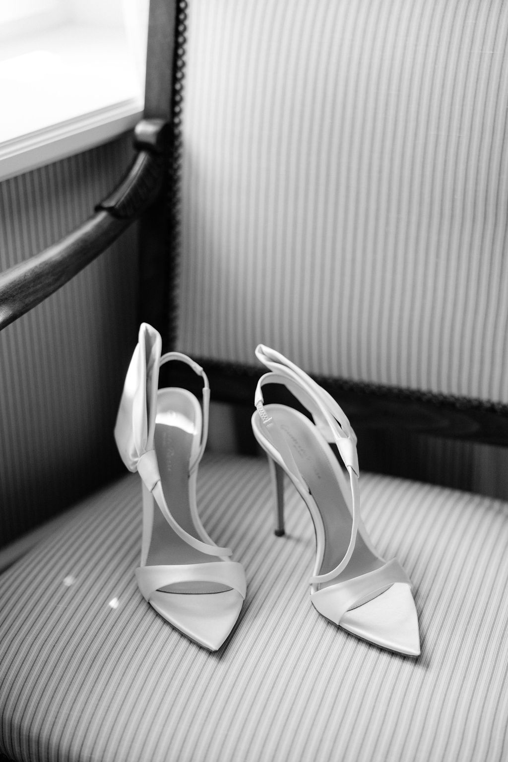 Bride's pointed white heels on a striped chair at Airelles Gordes La Bastide, Provence