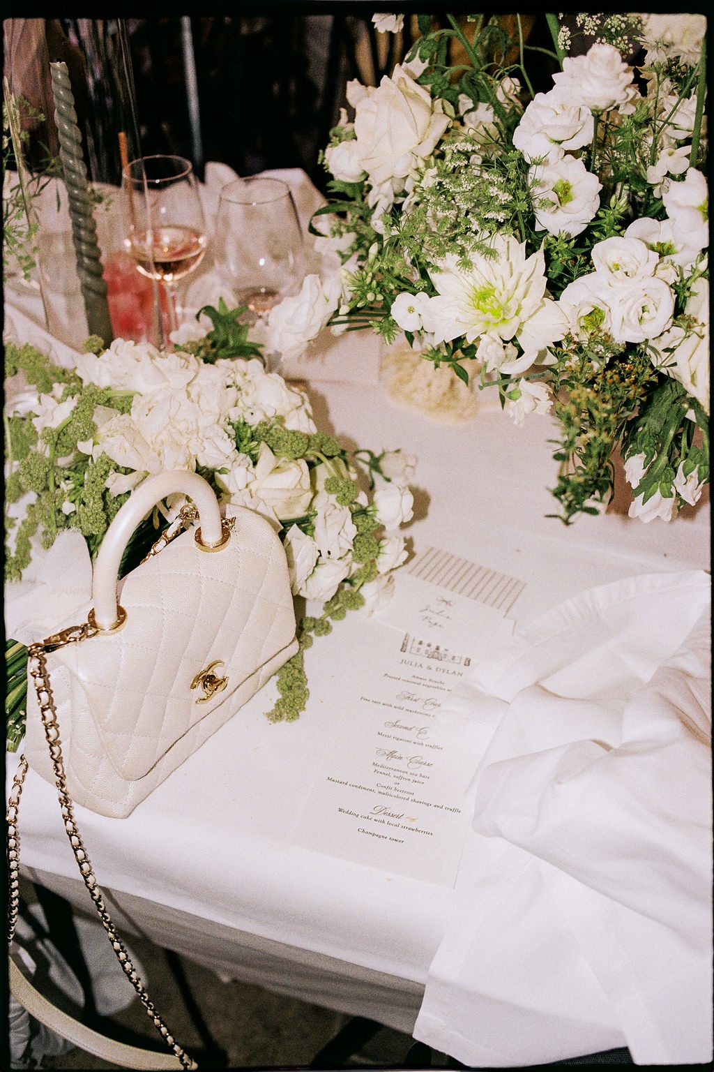 White Chanel bag with menu card and florals at Airelles Gordes La Bastide, Provence