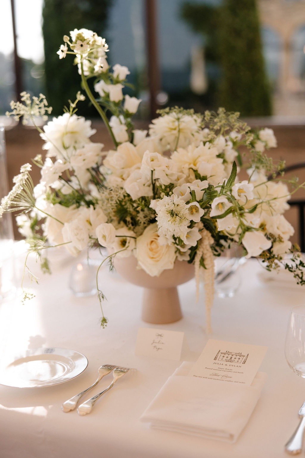 White floral centerpiece with Julia and Dylan menu card at Airelles Gordes La Bastide, Provence