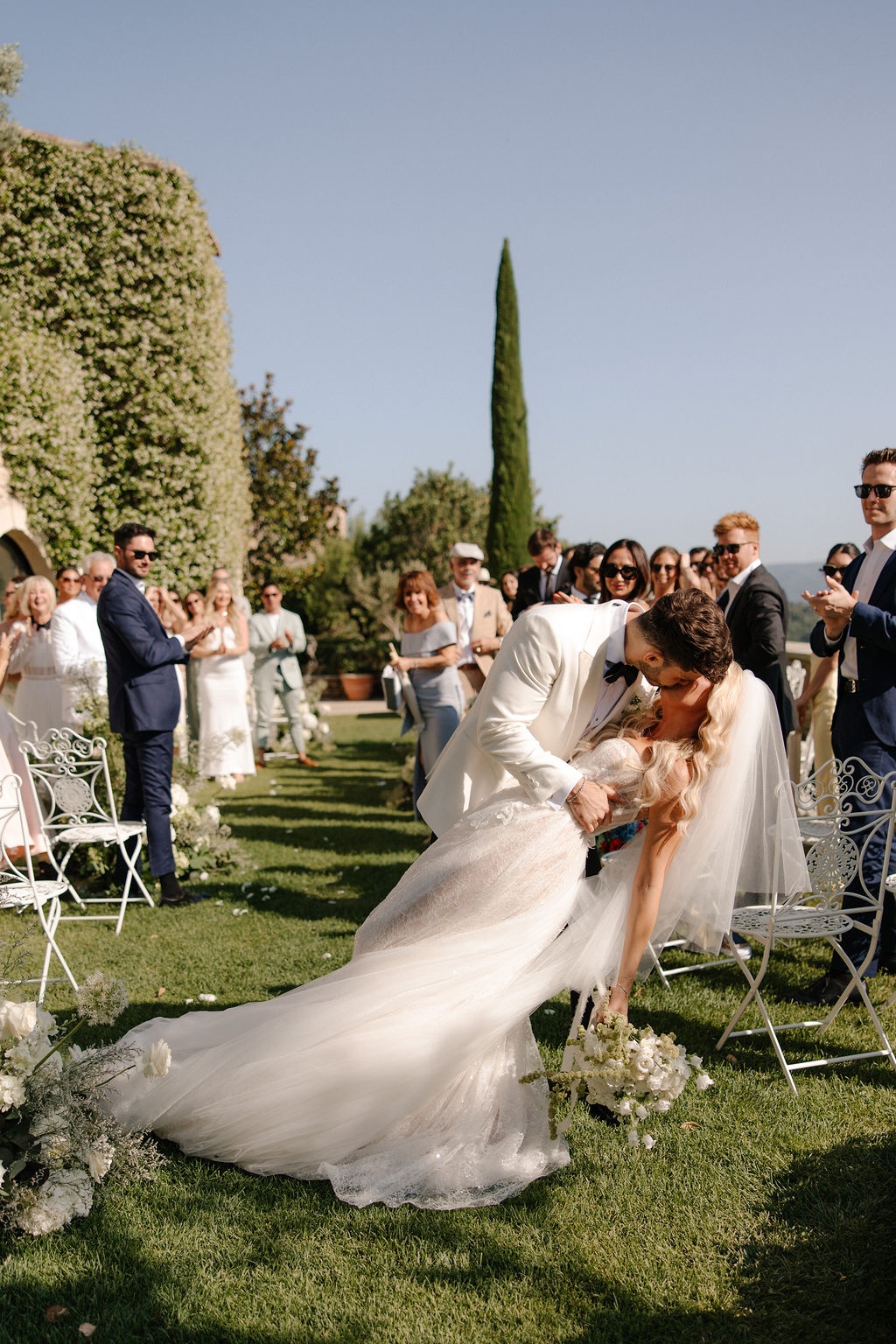 Groom dips bride for a kiss down the aisle at Airelles Gordes La Bastide, Provence